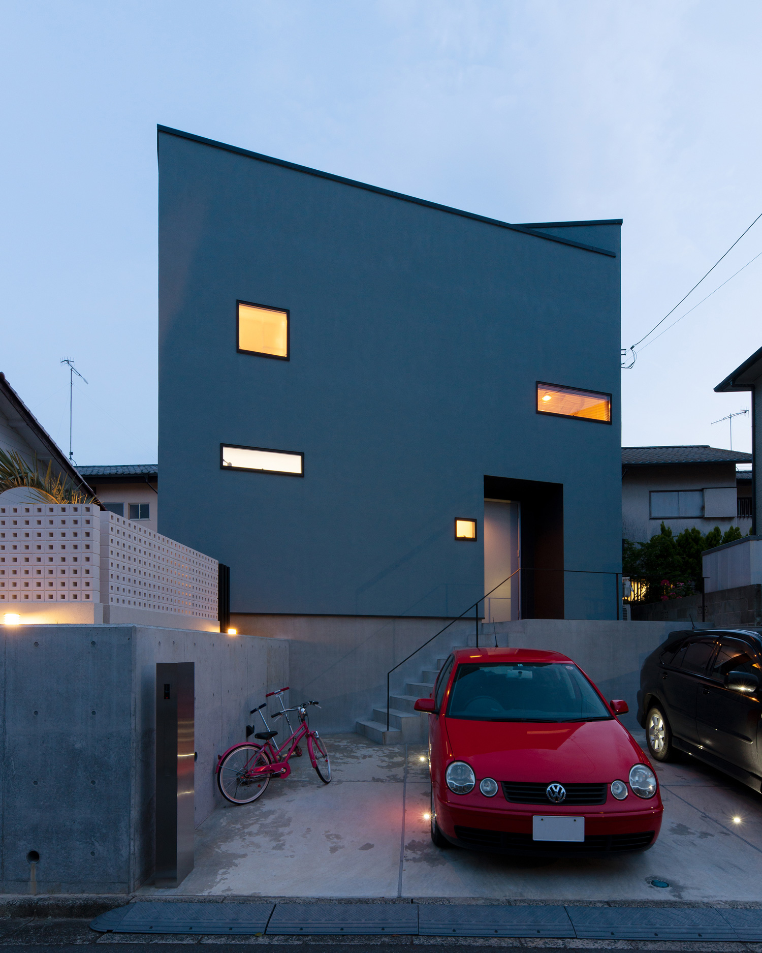 赤い車や自転車が置かれた、高基礎の住宅・デザイン住宅 注文住宅・デザイン住宅建築実例_『CASE621 対角線上の家』_外観