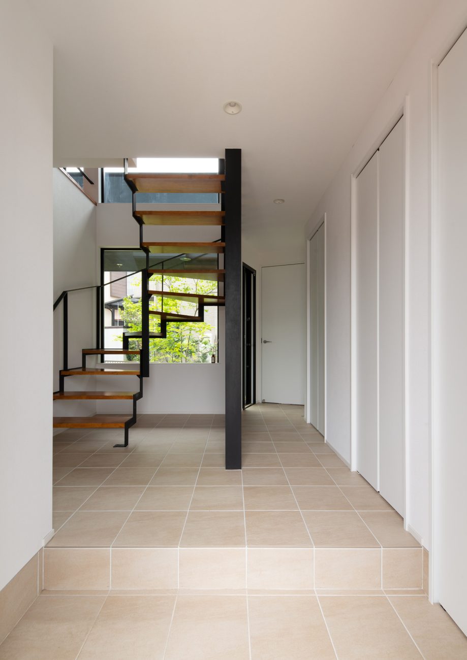 正面にスケルトン階段があるクリーム色のタイルの玄関・デザイン住宅 注文住宅・デザイン住宅建築実例_『CASE621 対角線上の家』_玄関