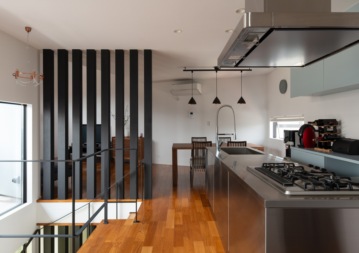 黒いルーバーの仕切りが設けられている、ステンレスのカウンターキッチンがあるLDK・デザイン住宅 注文住宅・デザイン住宅建築実例_『CASE621 対角線上の家』_LDK