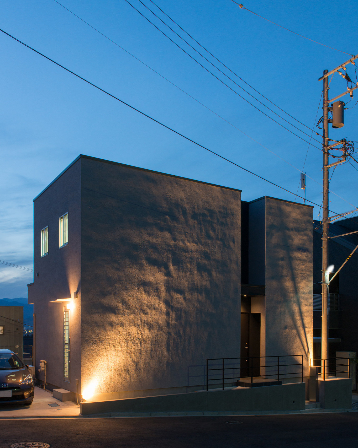 ライトアップされた白い外壁のキューブ状の住宅を斜めから見た様子・デザイン住宅 注文住宅・デザイン住宅建築実例_『CASE624 『７：３の家』』_外観