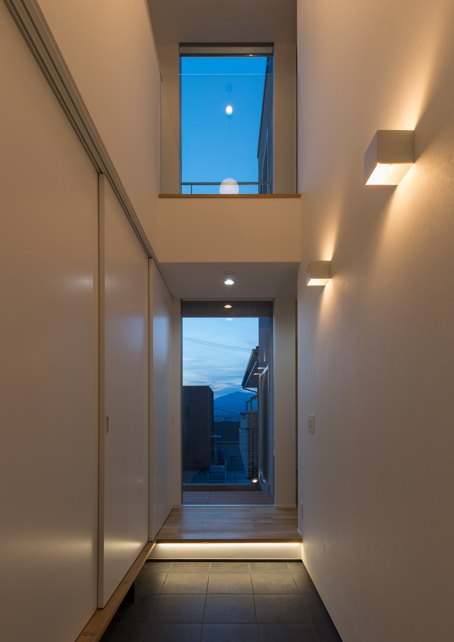 壁に間接照明が取り付けられた、正面に窓がある吹き抜けの玄関・デザイン住宅 注文住宅・デザイン住宅建築実例_『CASE624 『７：３の家』』_玄関