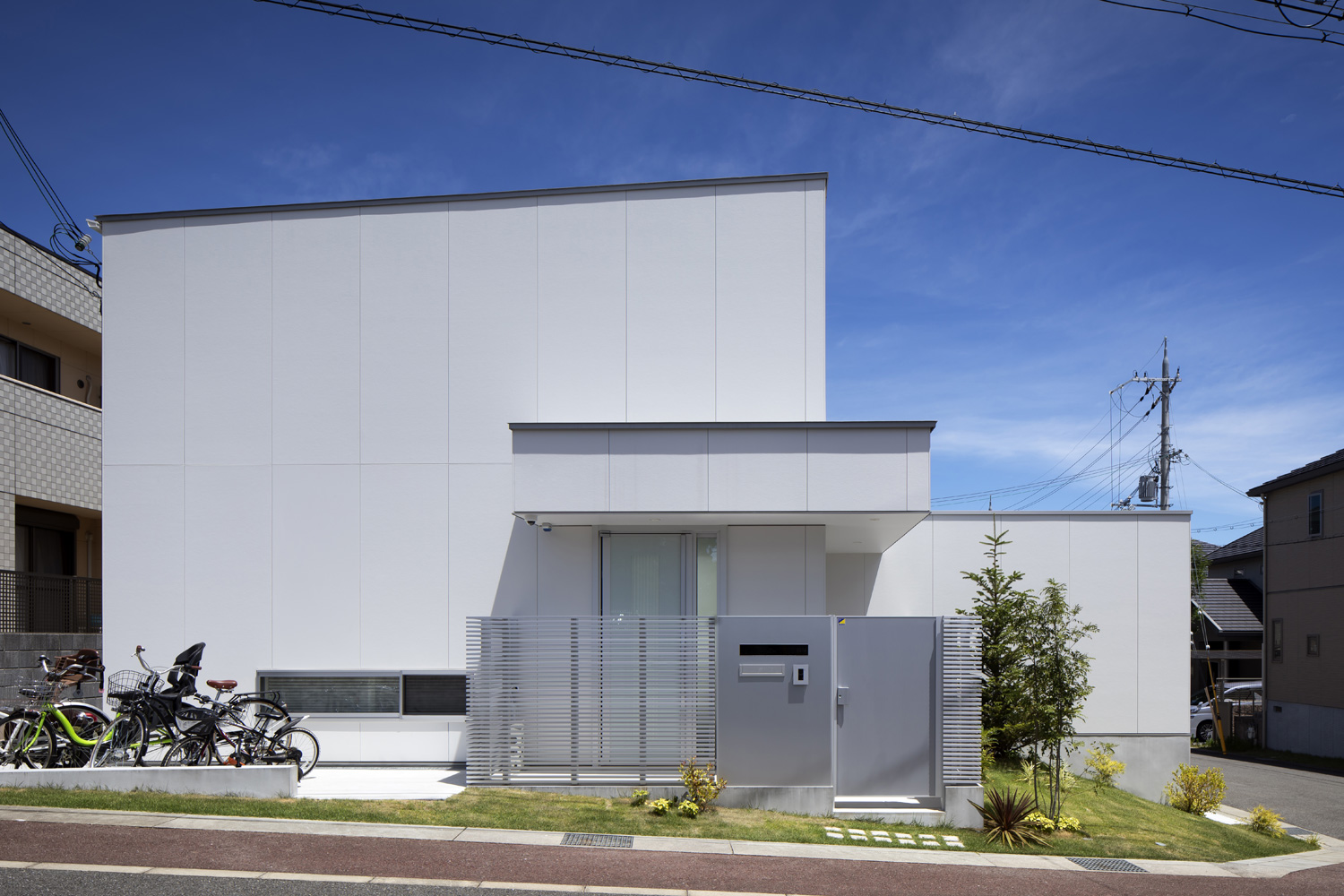 窓のない白い外壁で、シルバーの目隠しが玄関に建てられている住宅・デザイン住宅 注文住宅・デザイン住宅建築実例_『CASE627 HOUSE . GARAGE HOUSE』_外観