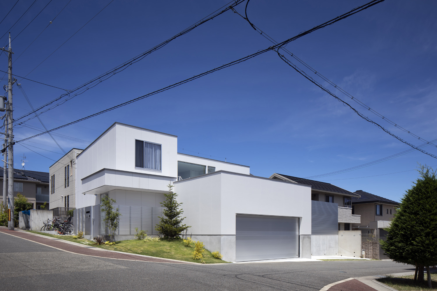 高低差のある角地に建つ、シャッター付きガレージのある住宅・デザイン住宅 注文住宅・デザイン住宅建築実例_『CASE627 HOUSE . GARAGE HOUSE』_外観