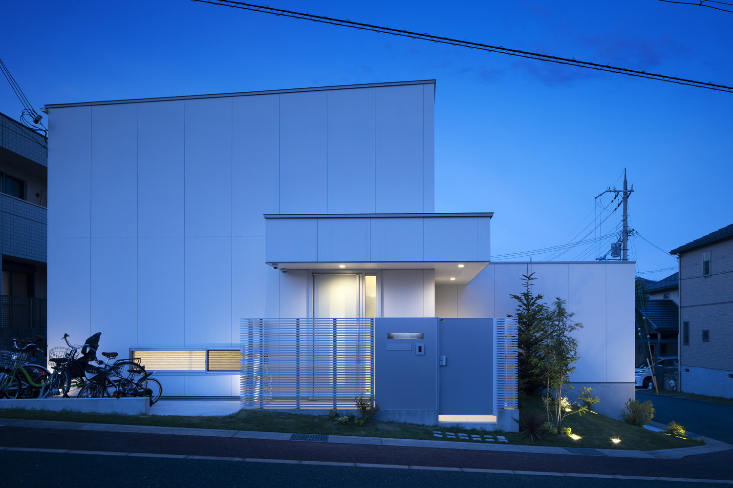 玄関の軒天井に照明が取り付けられた、窓の少ない白い外壁の住宅・デザイン住宅 注文住宅・デザイン住宅建築実例_『CASE627 HOUSE . GARAGE HOUSE』_外観