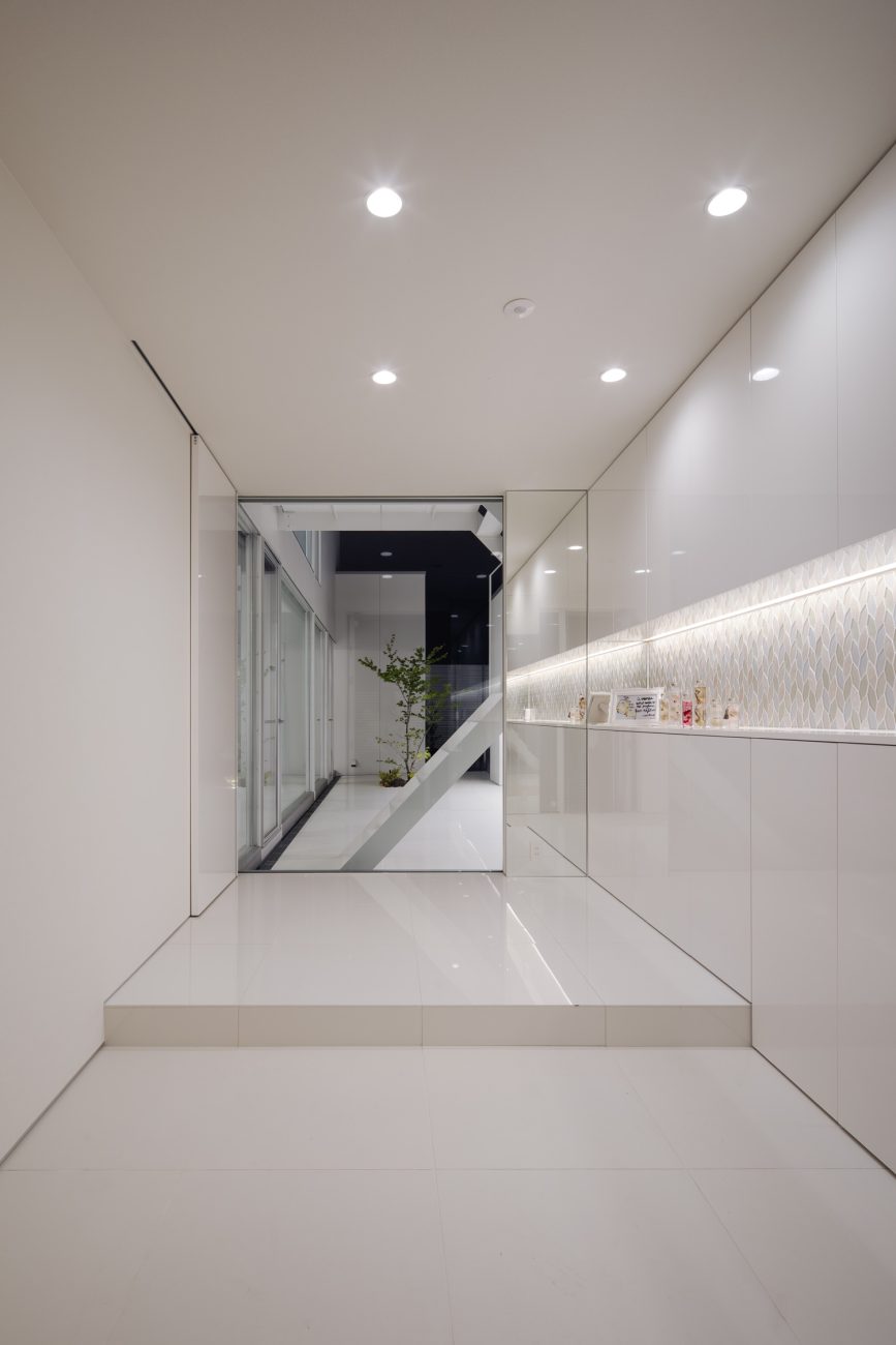 ニッチ壁に間接照明を取り付けた、正面に窓がある白で統一された玄関・デザイン住宅 注文住宅・デザイン住宅建築実例_『CASE627 HOUSE . GARAGE HOUSE』_玄関