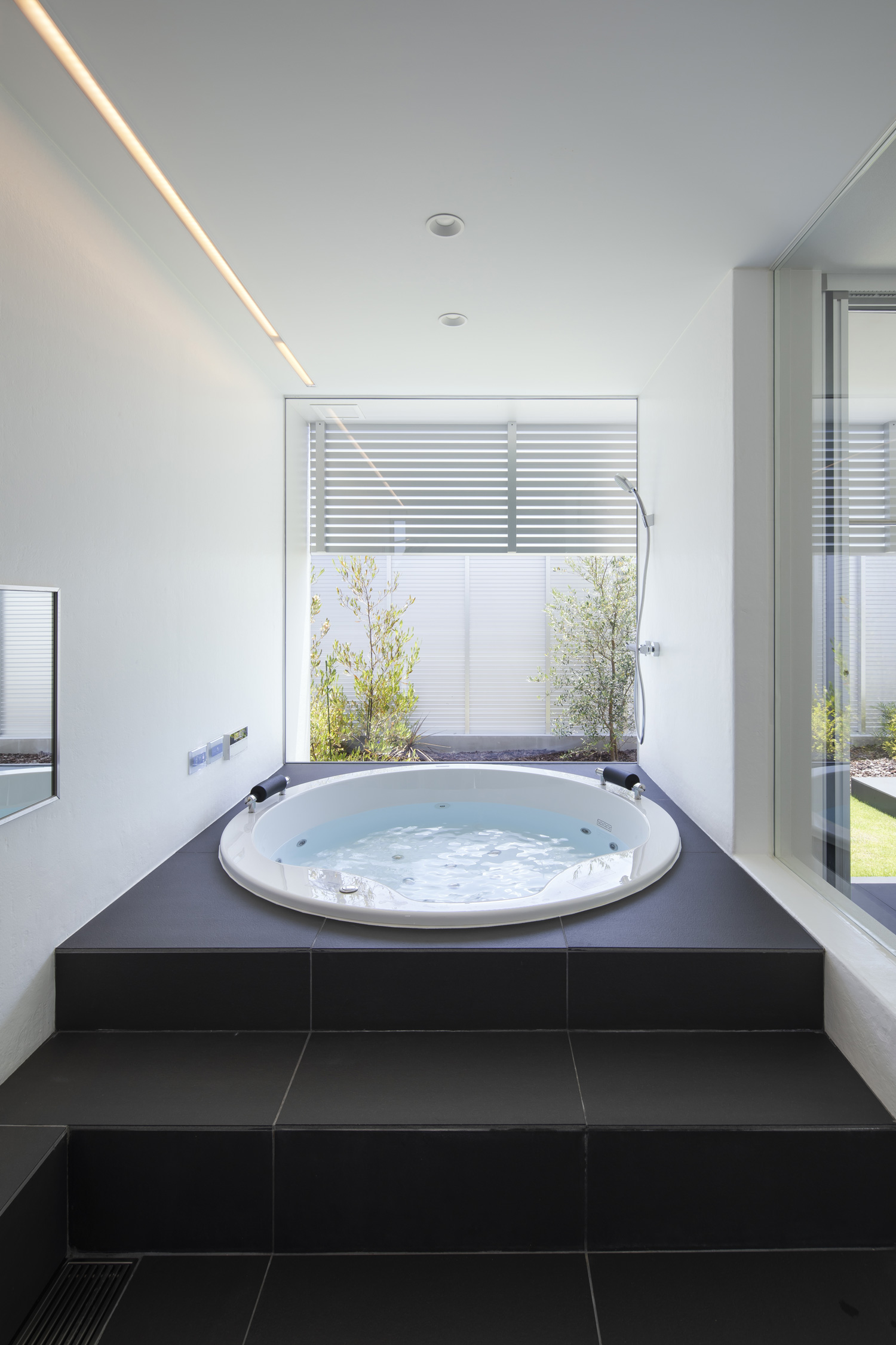 中庭の様子が見える、タイル床の丸い浴槽・デザイン住宅 注文住宅・デザイン住宅建築実例_『CASE627 HOUSE . GARAGE HOUSE』_浴室・洗面所