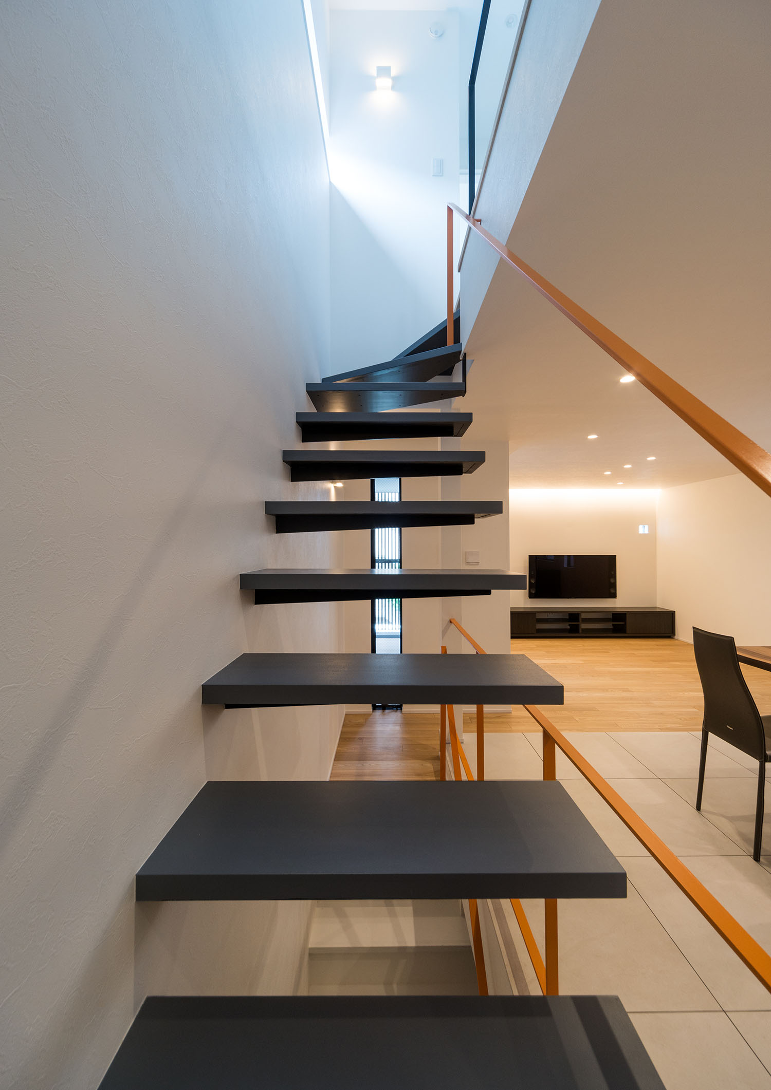 LDKのそばにある黒い浮いたデザインの階段・デザイン住宅 注文住宅・デザイン住宅建築実例_『CASE460 三色　～さんしき～』_階段