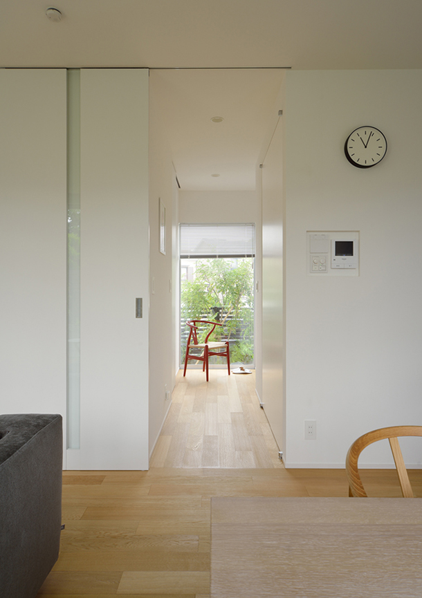 廊下の突き当りが窓になっていて緑が見えるシンプルなLDK・デザイン住宅