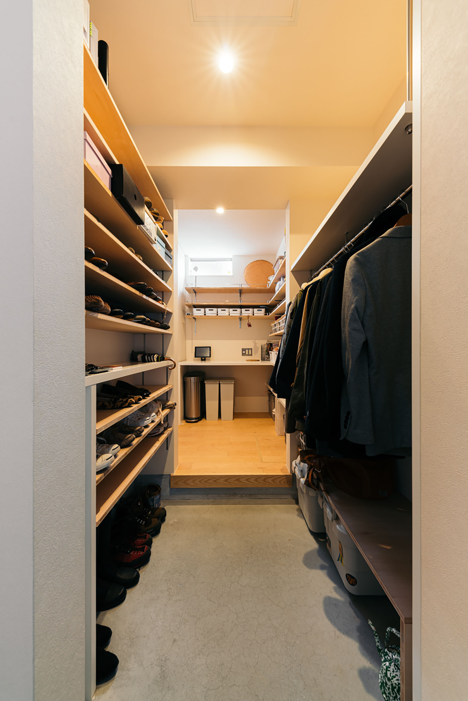 土間のウォークインクローゼットに靴や洋服が掛けられている様子・ホビールームのある家 注文住宅・デザイン住宅建築実例_『CASE684  ホビールームのある家』_玄関