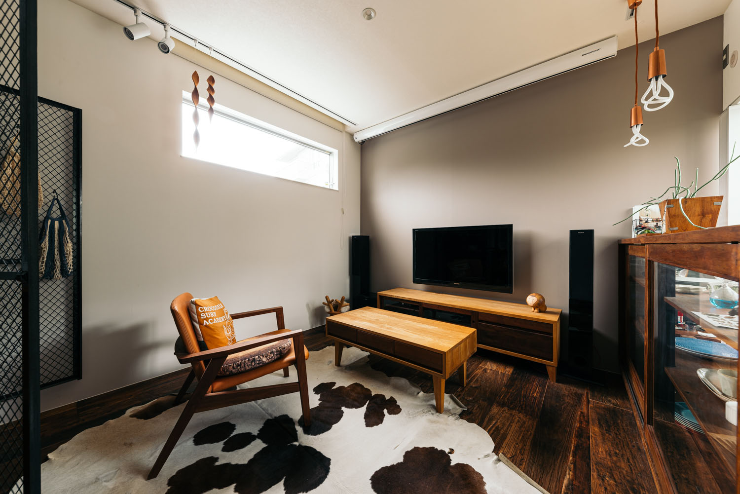 濃い色のフローリングの上にラグがありスリット窓が設けられた部屋・ホビールームのある家 注文住宅・デザイン住宅建築実例_『CASE684  ホビールームのある家』_ホビールーム