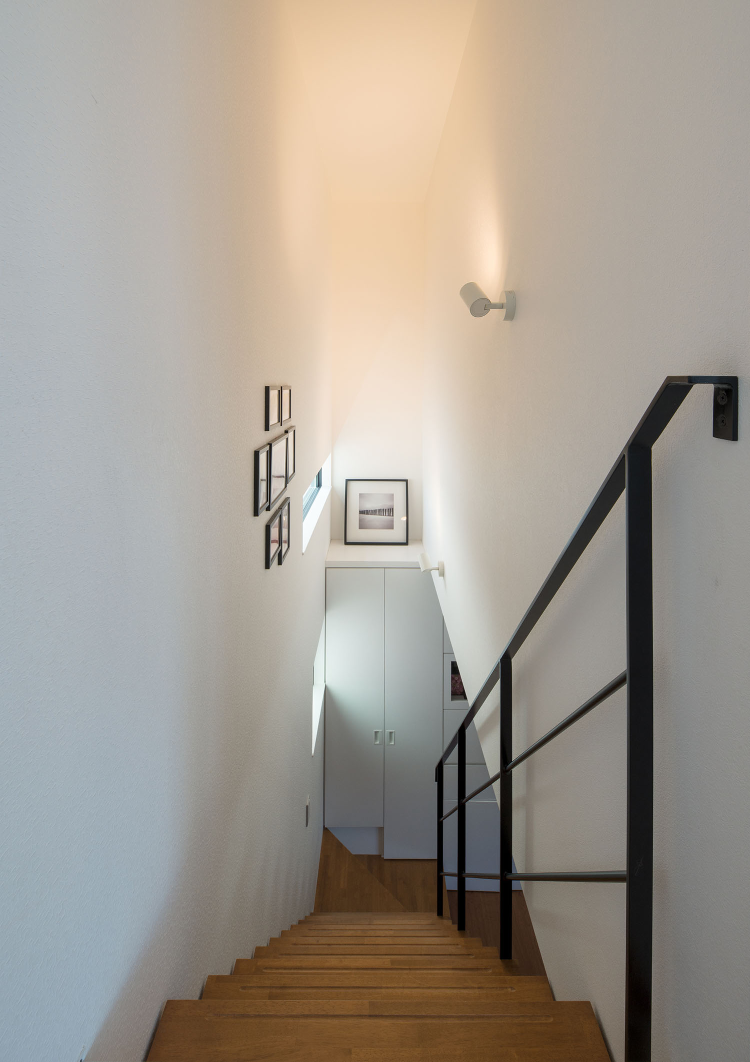 壁に間接照明を取り付けたアイアンの手すり付きの階段室・デザイン住宅 注文住宅・デザイン住宅建築実例_『CASE536 Preppy』_階段