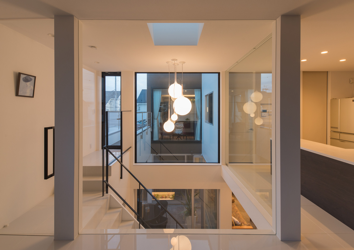 丸いペンダントライトが取り付けられた吹き抜けの階段部分・デザイン住宅 注文住宅・デザイン住宅建築実例_『CASE593 CAMP』_LDK