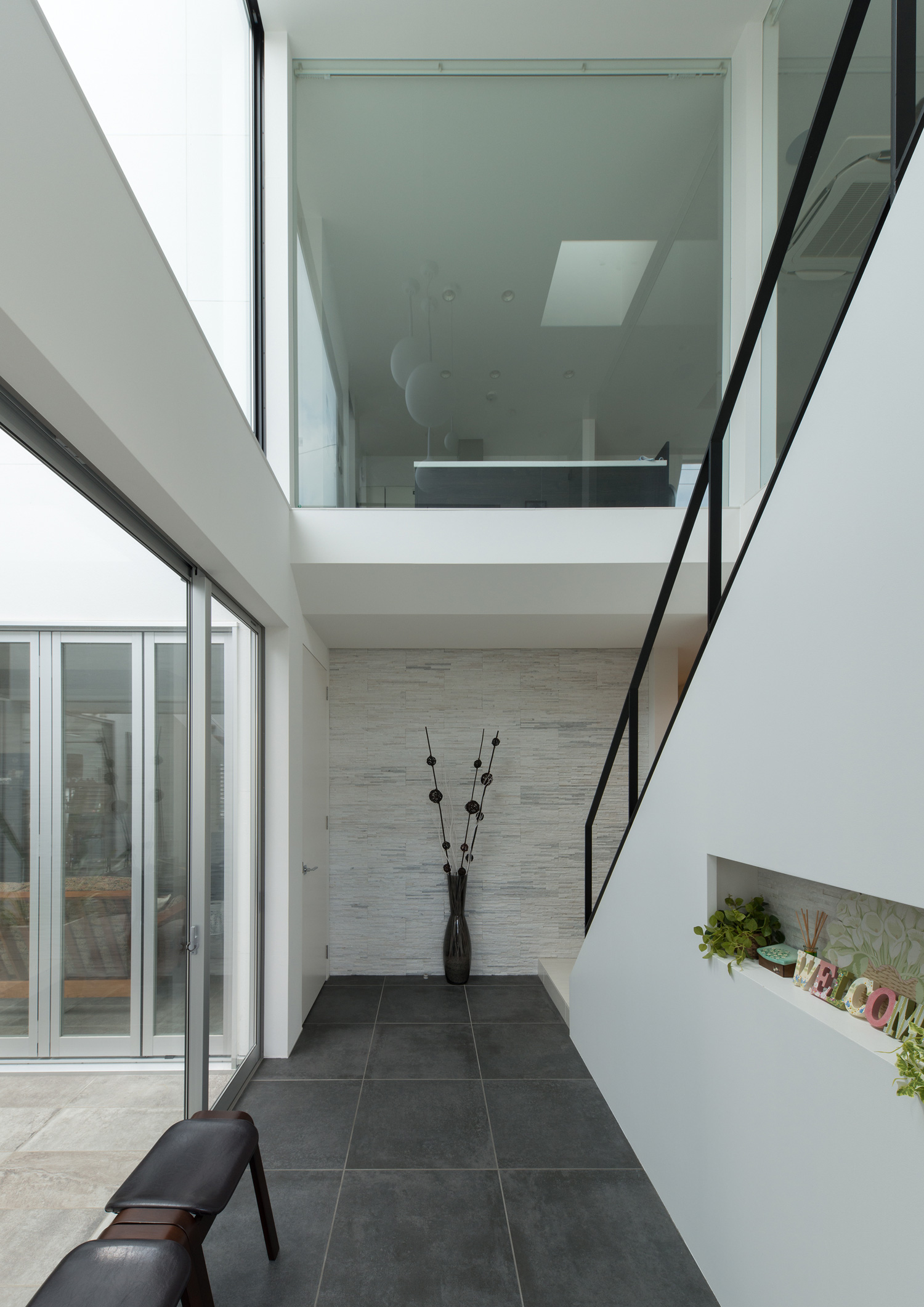 中庭に面した窓がある吹き抜けの玄関・デザイン住宅 注文住宅・デザイン住宅建築実例_『CASE593 CAMP』_玄関