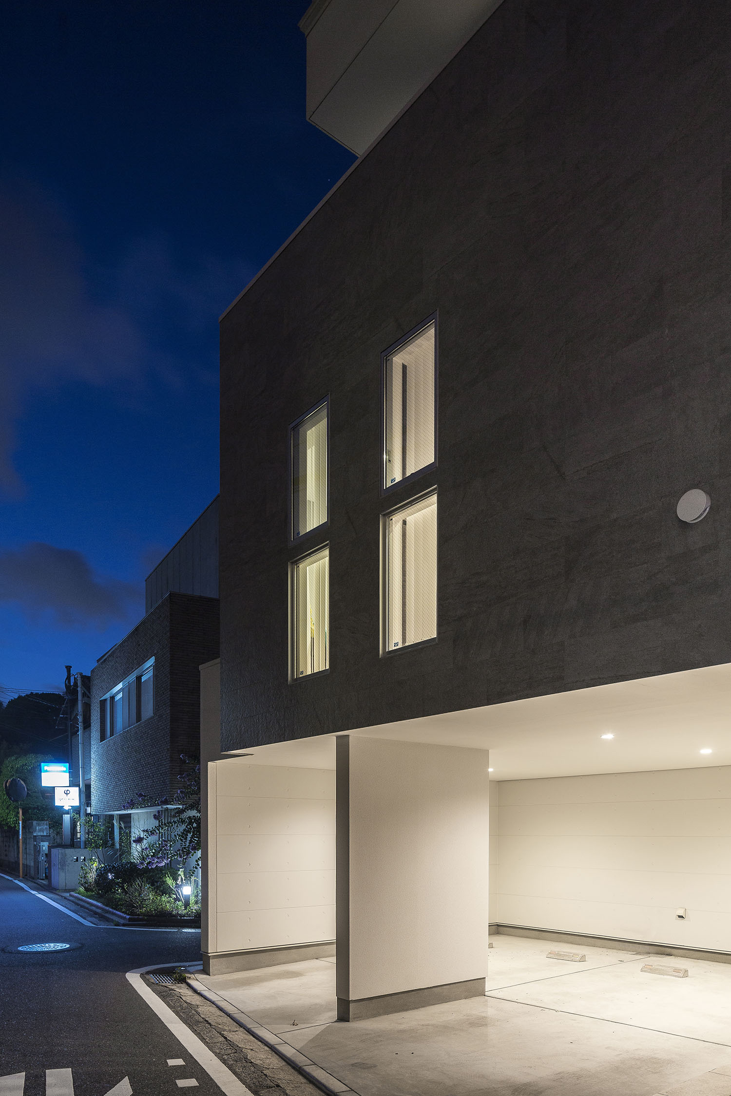 インナーガレージの中に照明が取り付けられたタイルの外観の住まい・デザイン住宅 注文住宅・デザイン住宅建築実例_『CASE476 3FLDK』_外観