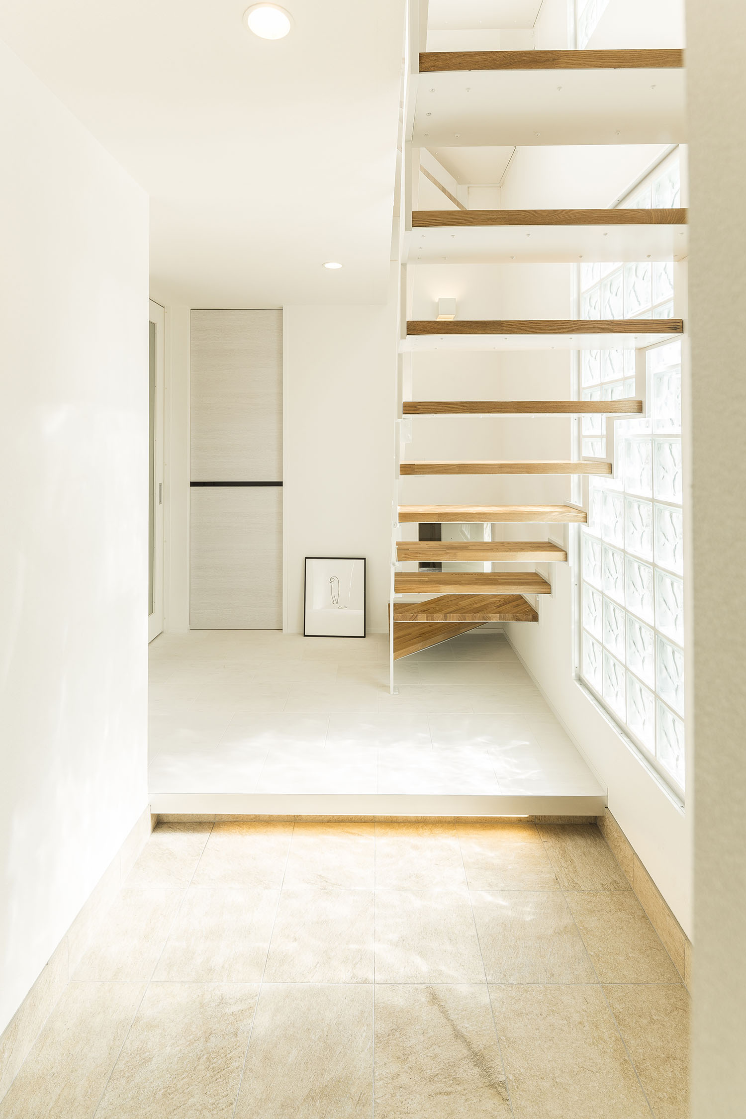 ガラスタイルの窓から光が入るスケルトン階段のある玄関・デザイン住宅 注文住宅・デザイン住宅建築実例_『CASE476 3FLDK』_玄関