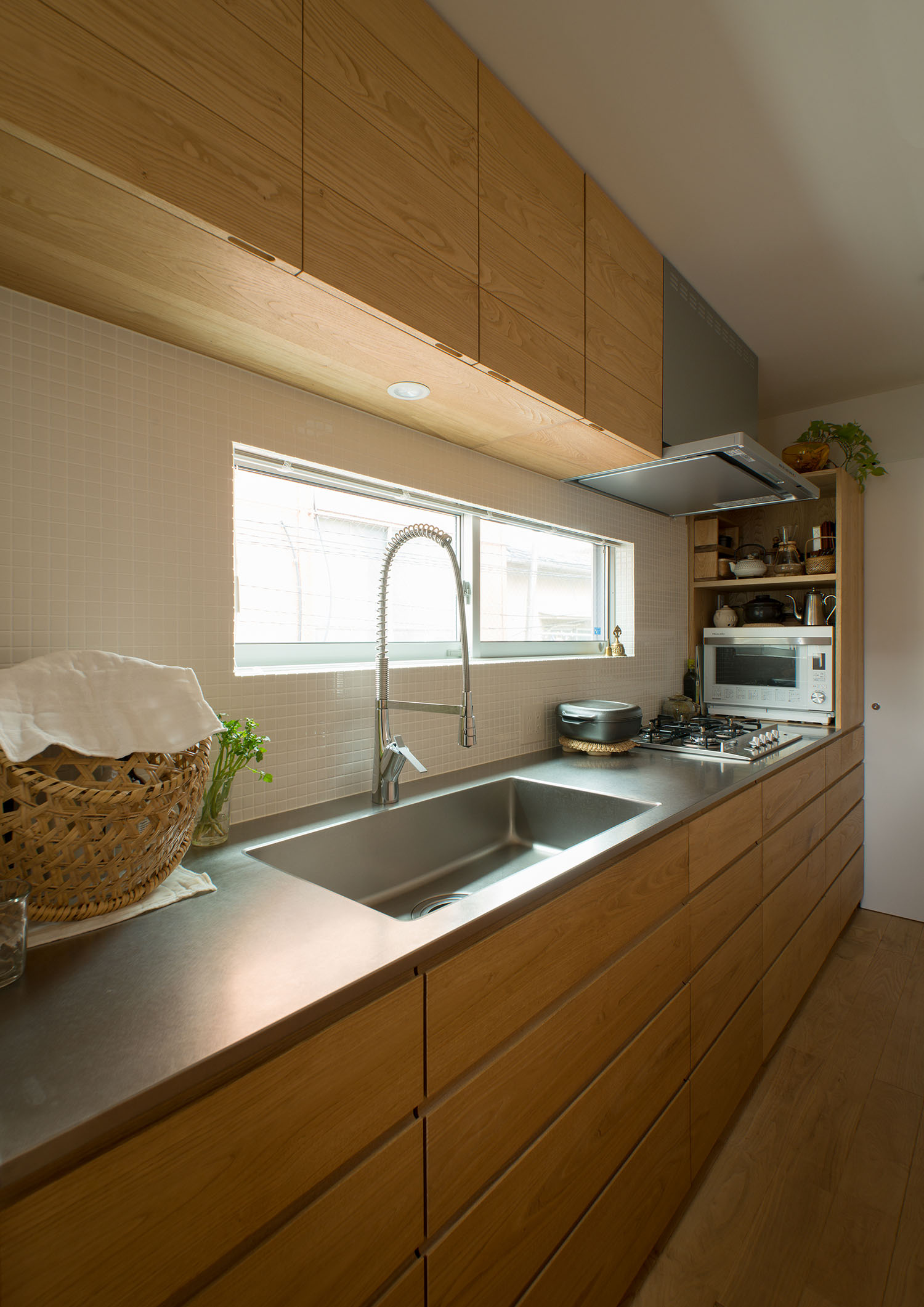 頭上に収納がありスリット窓がある木のキッチン・デザイン住宅 注文住宅・デザイン住宅建築実例_『CASE487 立方の家』_キッチン