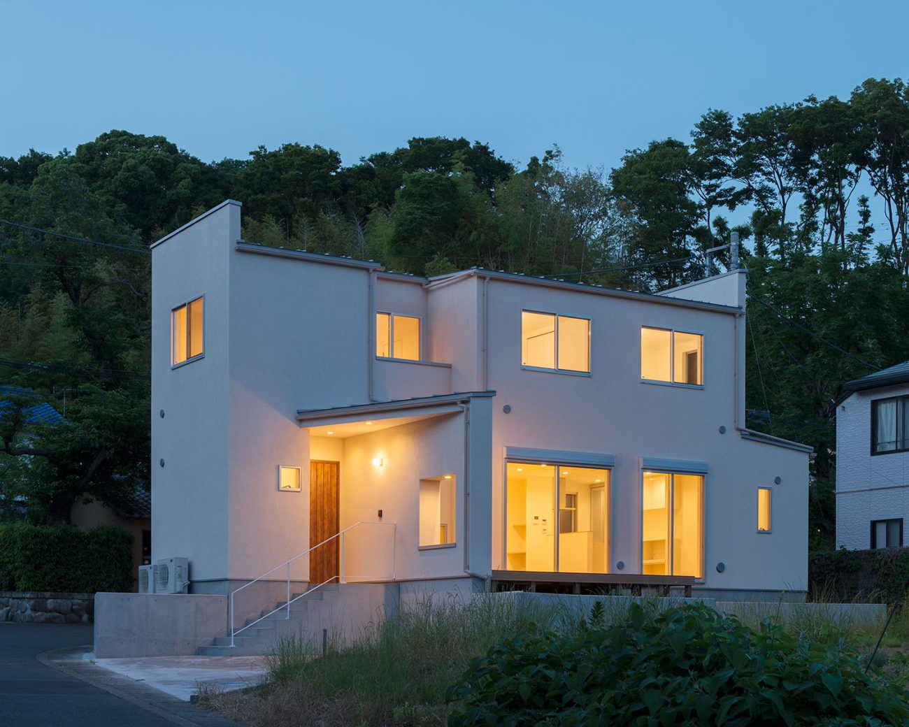 窓から光が漏れる庭付きの白い外壁の家・デザイン住宅 注文住宅・デザイン住宅建築実例_『CASE550 three box house』_外観