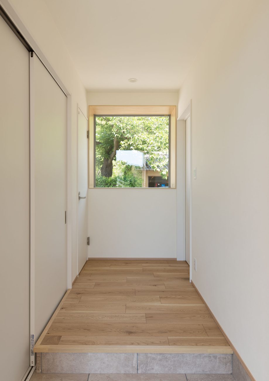 緑が見える正方形の窓が突き当りにある玄関・デザイン住宅 注文住宅・デザイン住宅建築実例_『CASE550 three box house』_玄関
