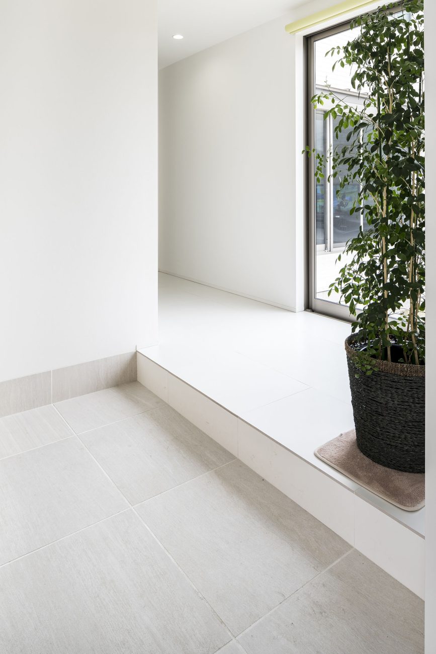 壁や床が白い室内に繋がるタイルの玄関・デザイン住宅 注文住宅・デザイン住宅建築実例_『CASE581 Tcourt』_玄関