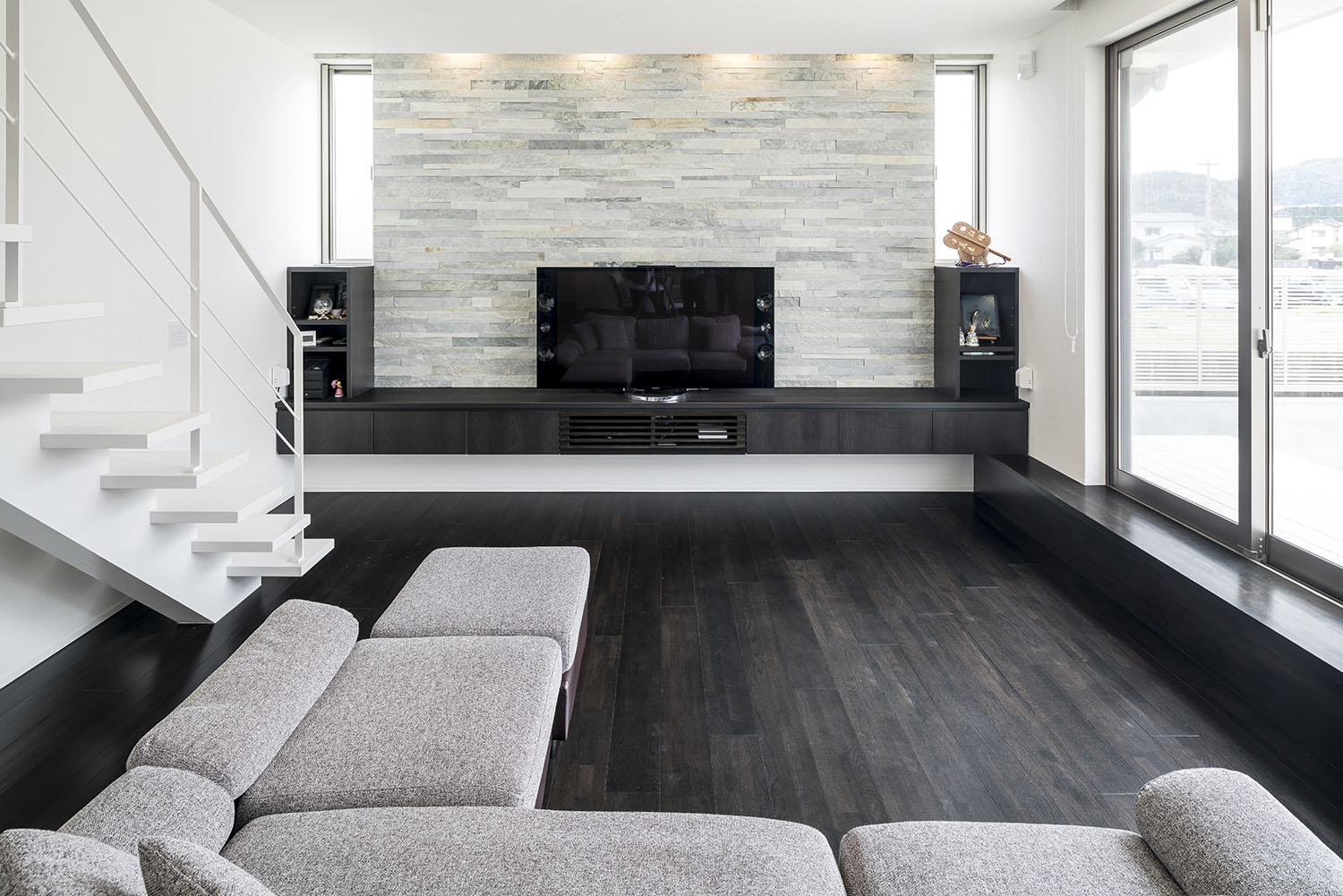 石のアクセントウォールにテレビボードを設けたL字ソファーのあるLDK・デザイン住宅 注文住宅・デザイン住宅建築実例_『CASE581 Tcourt』_LDK