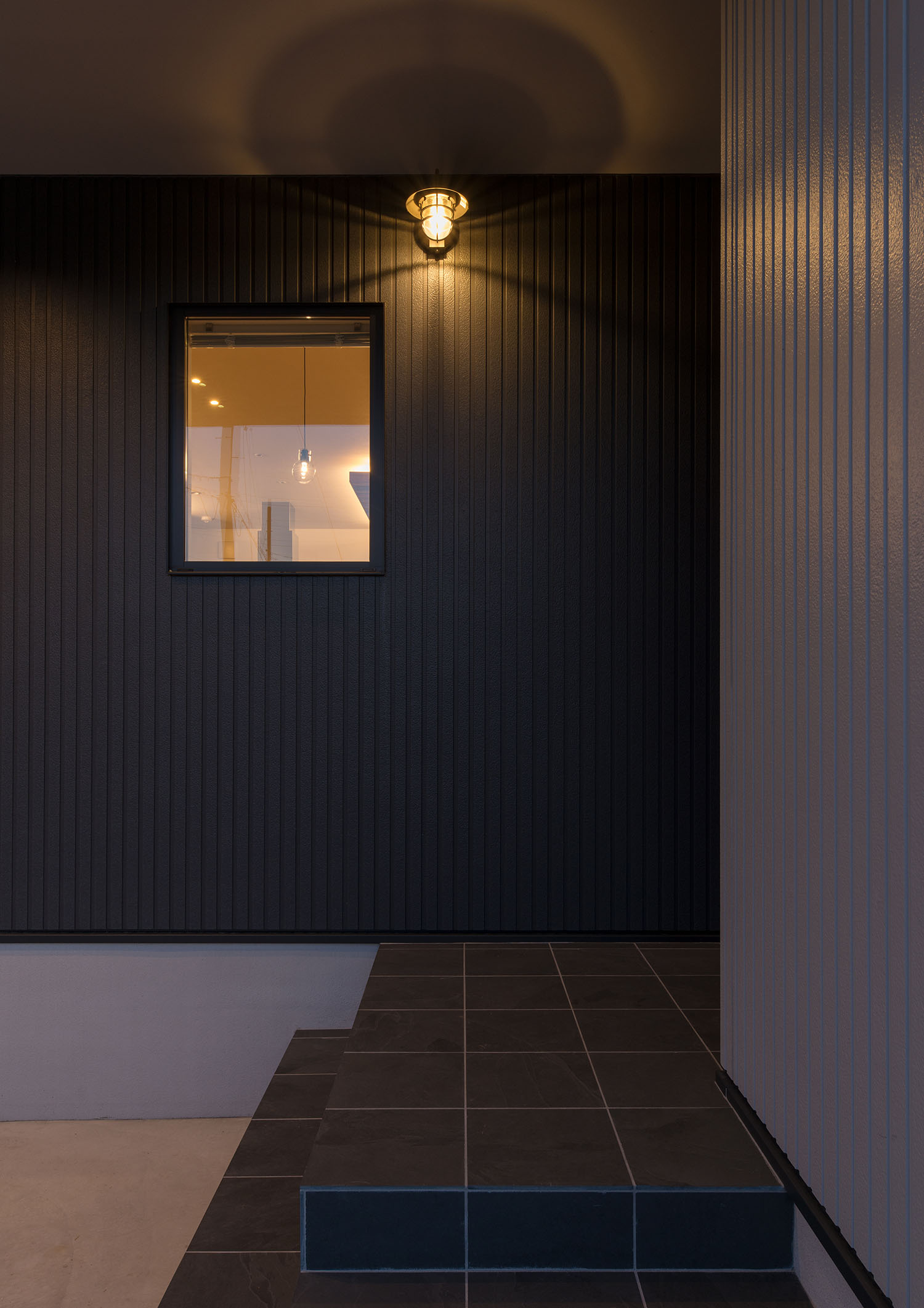 黒い外壁に照明が取り付けられた玄関アプローチ・デザイン住宅 注文住宅・デザイン住宅建築実例_『CASE591 Moist』_外観