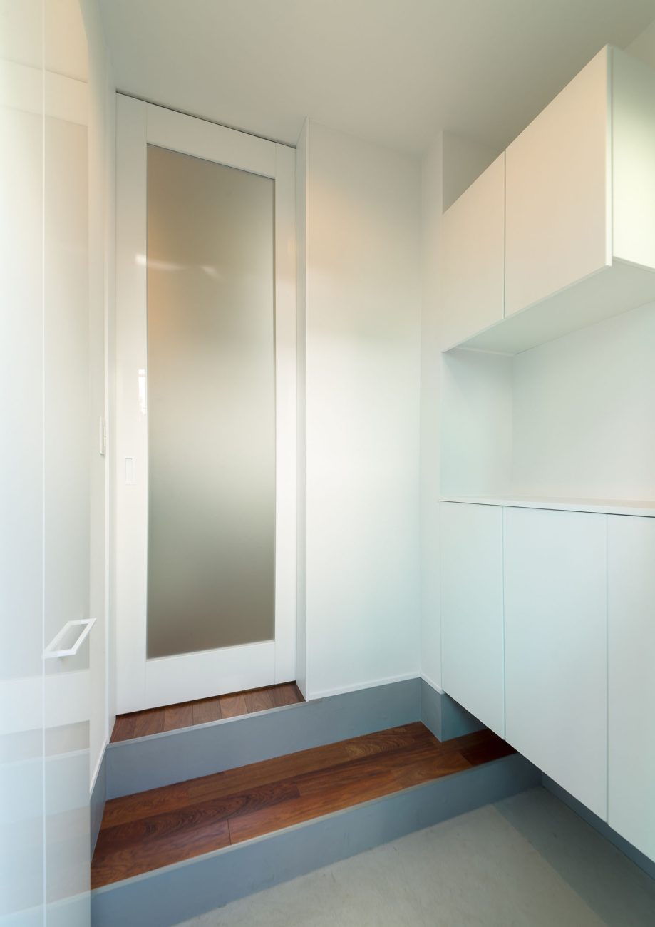 正面に曇りガラスの扉が取り付けられた、白い壁付けの収納がある玄関・デザイン住宅 注文住宅・デザイン住宅建築実例_『CASE625 ヒカリの家』_玄関