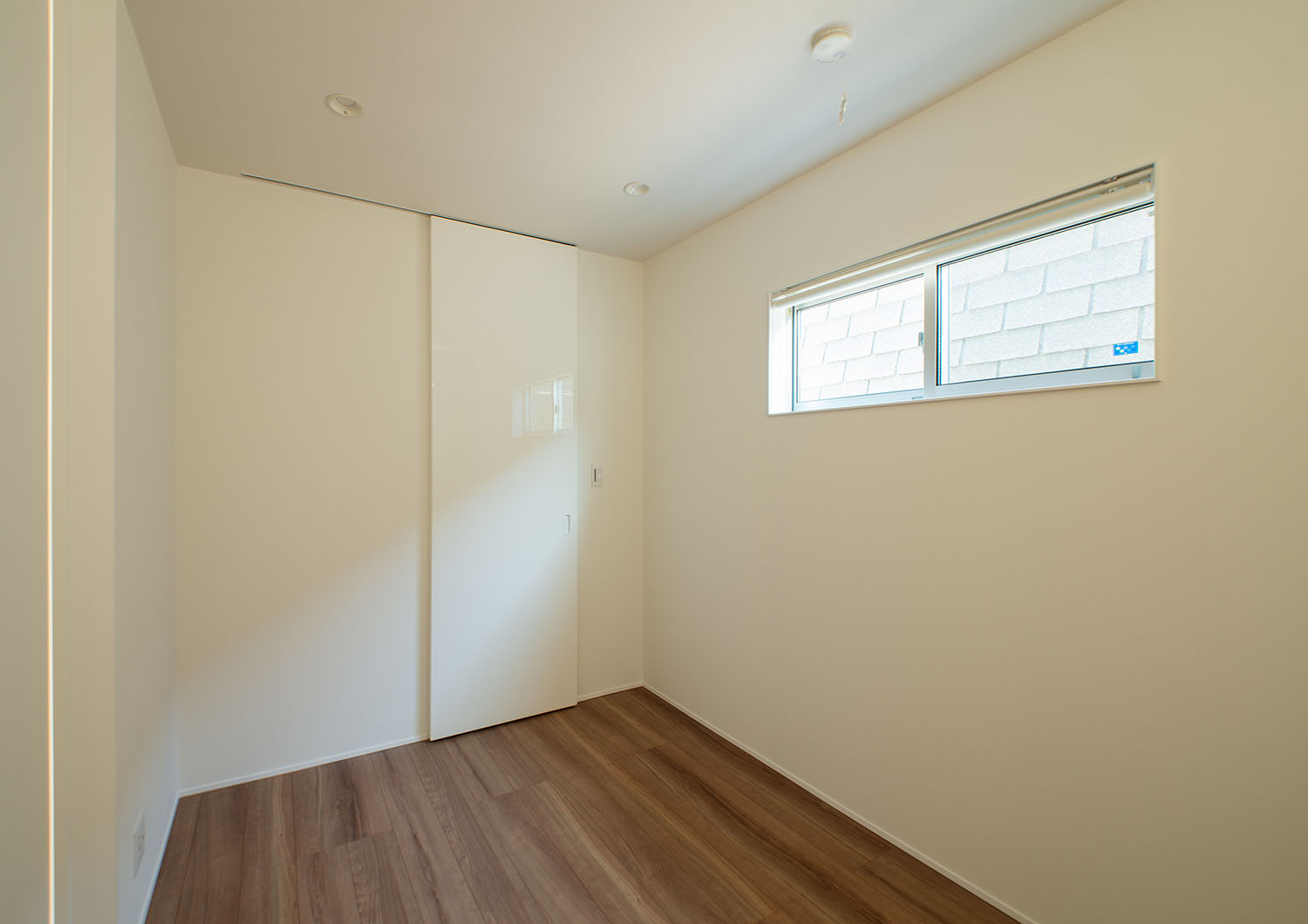 壁と引き戸が白で統一された横長のスリット窓がある寝室・デザイン住宅 注文住宅・デザイン住宅建築実例_『CASE625 ヒカリの家』_寝室