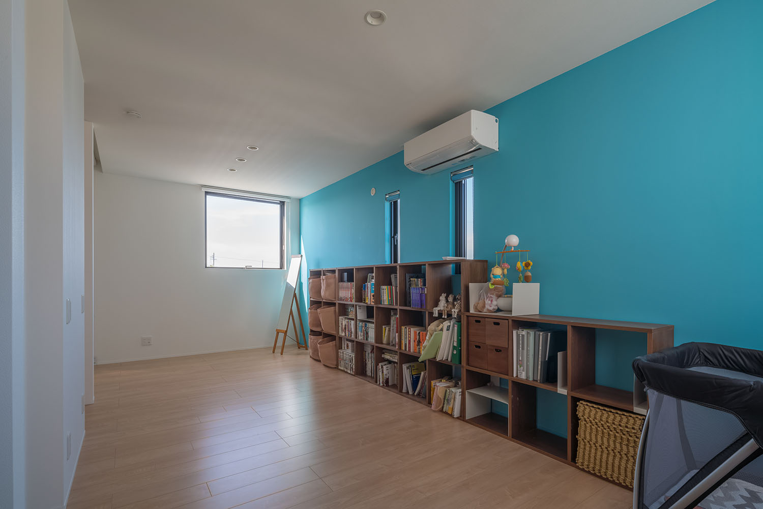 ブルーのアクセントクロスがある、壁際に本棚を置いた子供部屋・デザイン住宅 注文住宅・デザイン住宅建築実例_『CASE505 silhouette』_子供部屋