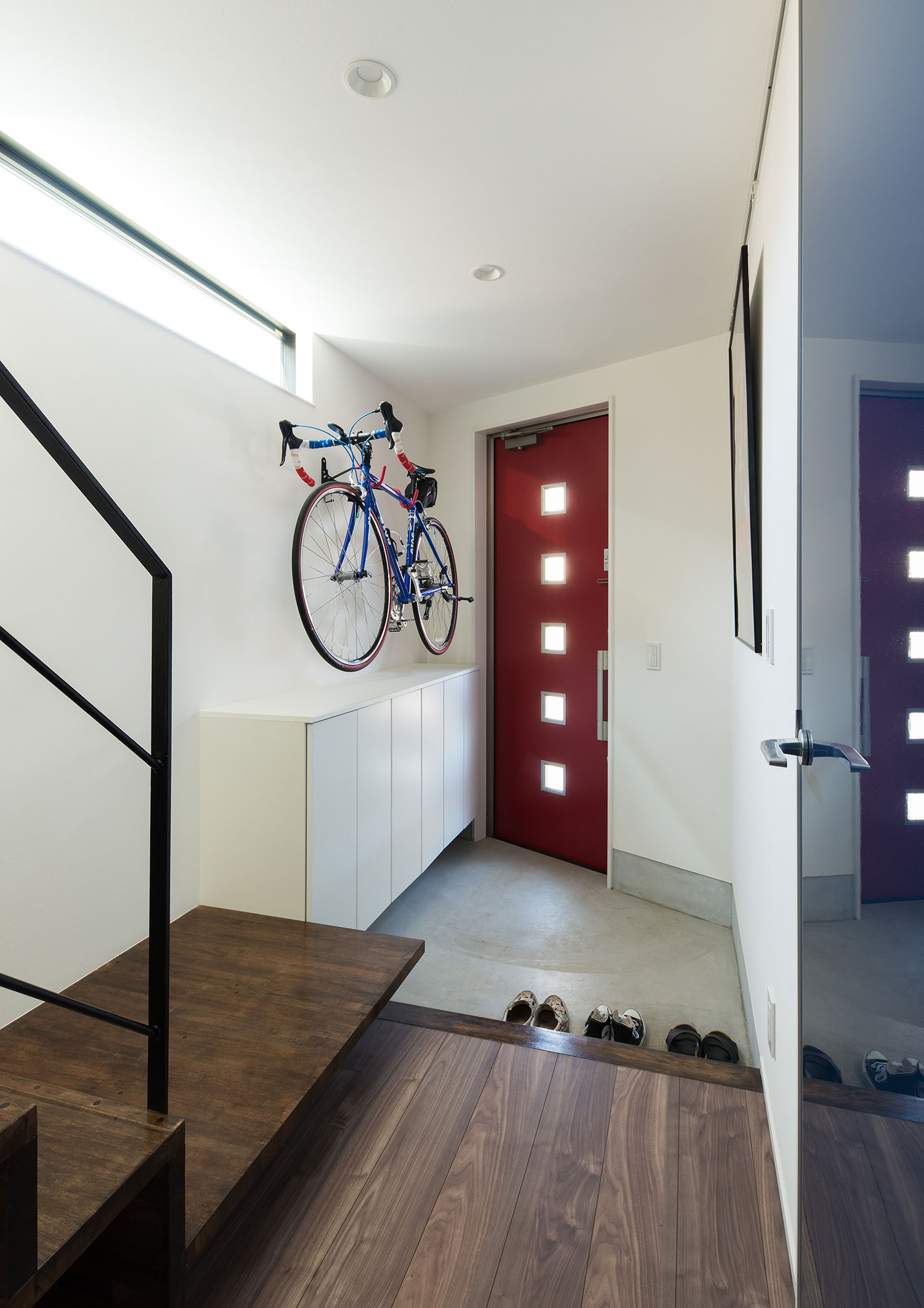 自転車が壁にかけられている赤い玄関扉の玄関・デザイン住宅 注文住宅・デザイン住宅建築実例_『CASE594 TOOL　BOX』_玄関