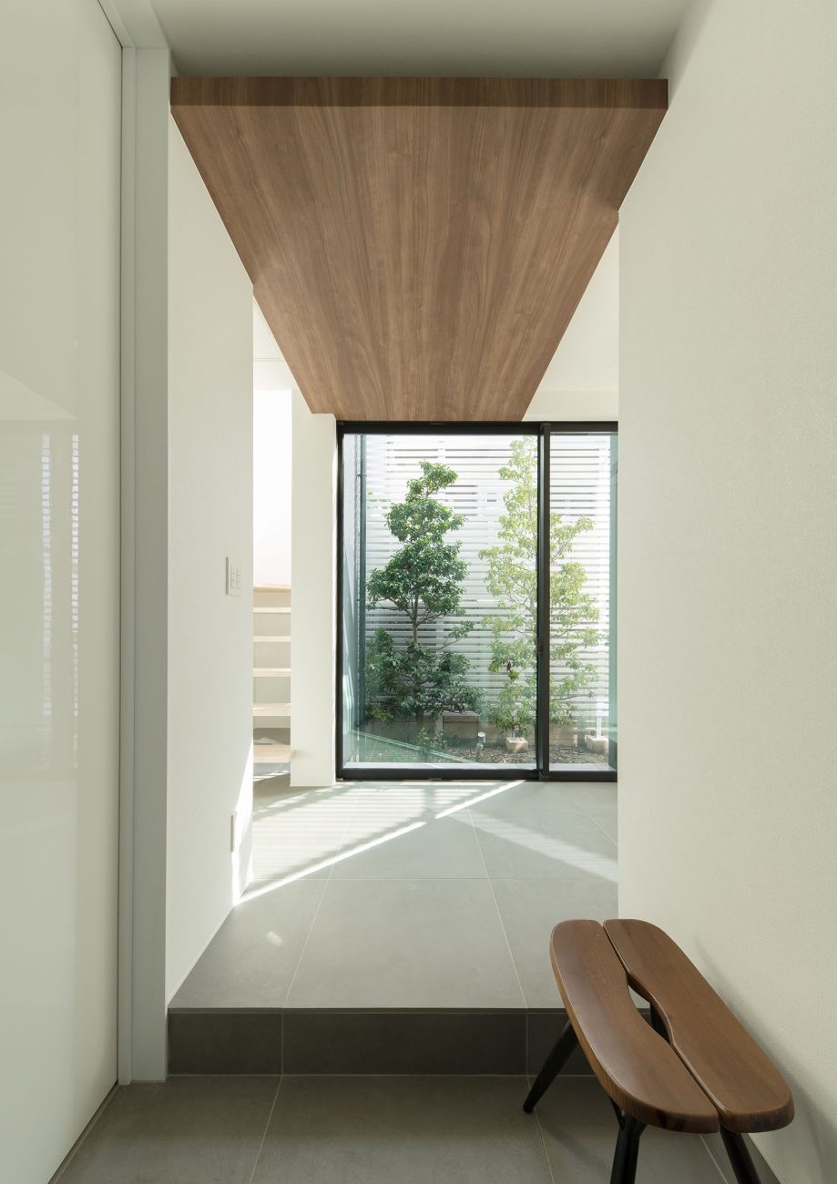 中庭が見える窓のある、ベンチを置いた玄関・デザイン住宅 注文住宅・デザイン住宅建築実例_『CASE597 Ambiguous Expression』_玄関