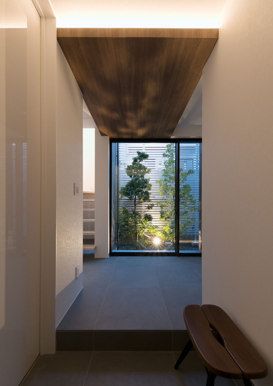 木目の天井に間接照明を取り付けた、中庭の見える窓がある玄関・デザイン住宅 注文住宅・デザイン住宅建築実例_『CASE597 Ambiguous Expression』_玄関