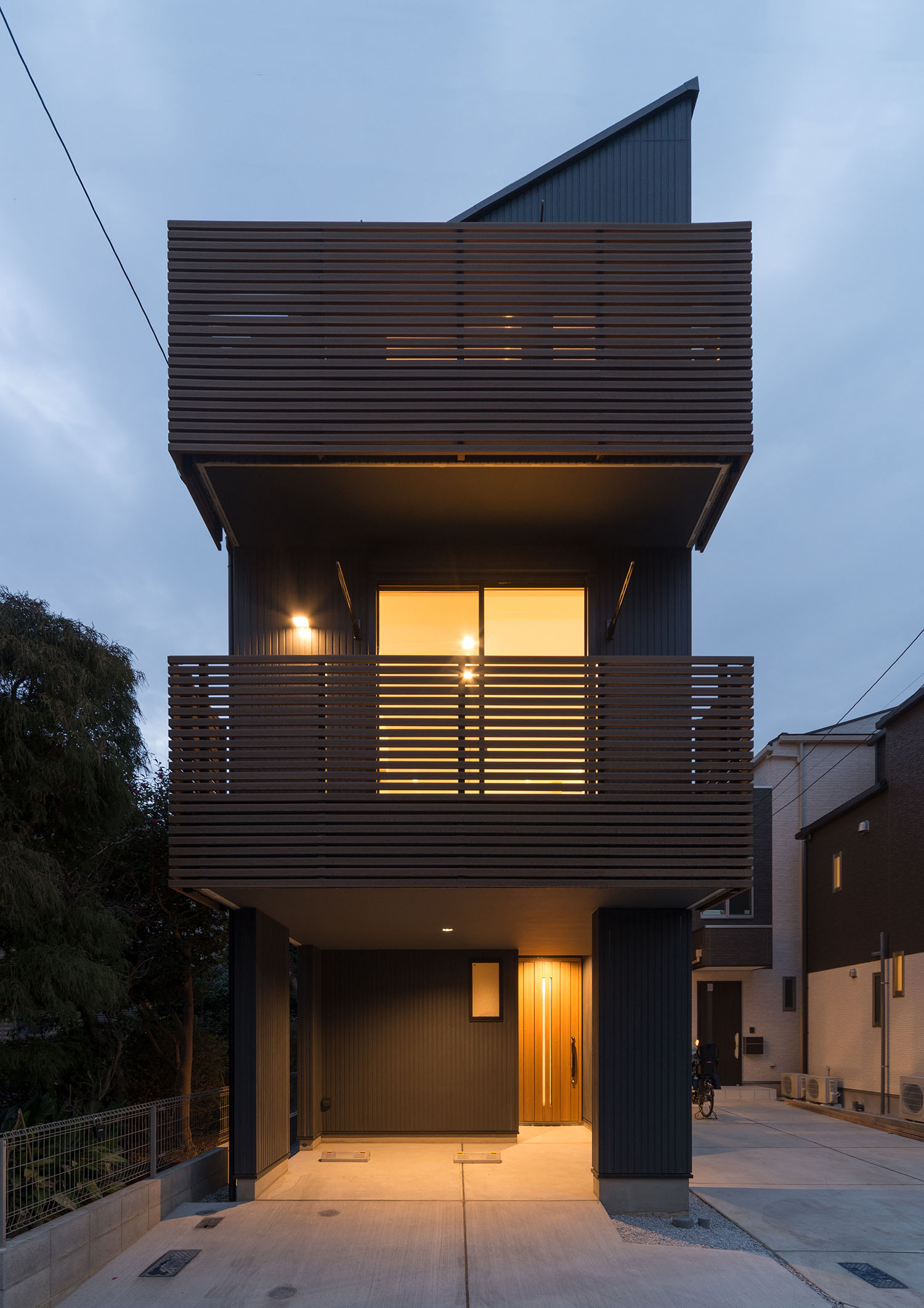 玄関前の駐車スペースとルーバーの目隠し付きのベランダがある三階建て住宅・デザイン住宅 注文住宅・デザイン住宅建築実例_『CASE599 日向ぼっこしたくなる階段のある家』_外観