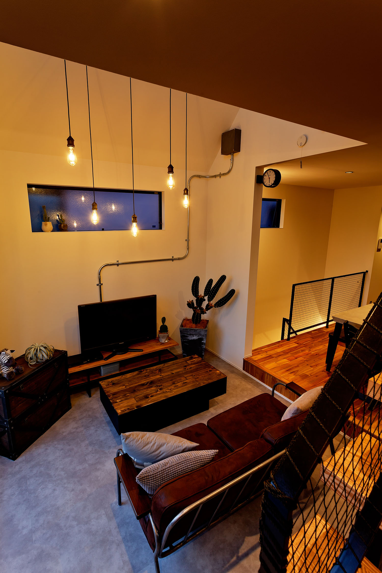 複数のペンダントが吊り下げられたグレーの床のLDK・デザイン住宅 注文住宅・デザイン住宅建築実例_『CASE604 “LIKE”』_LDK