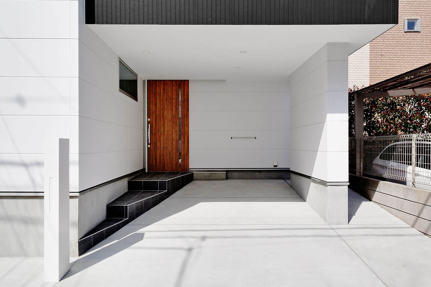 ガレージに隣接した木の玄関扉があるエントランス・デザイン住宅 注文住宅・デザイン住宅建築実例_『CASE618 陽が射す家』_外観