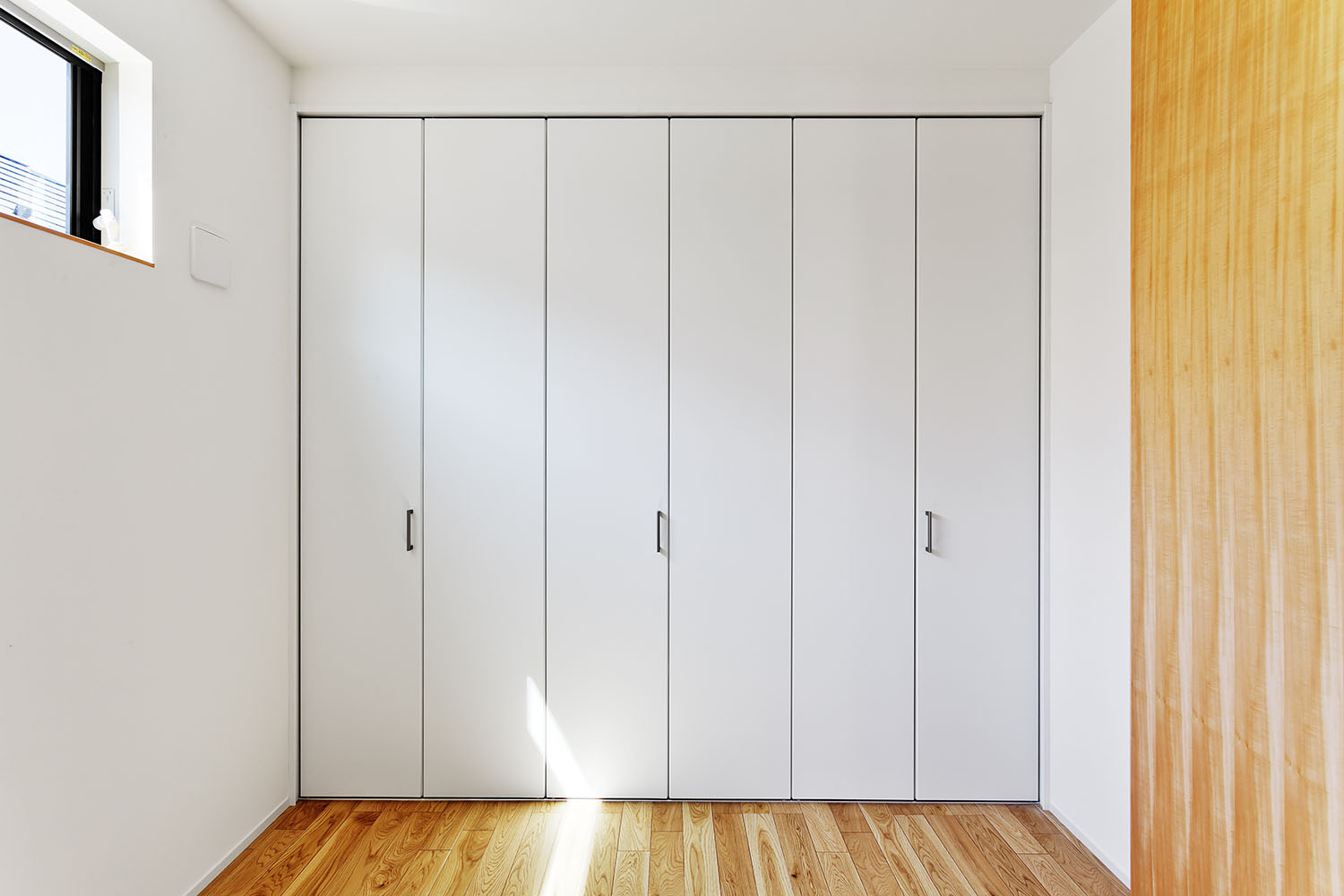 壁と同化するようなクローゼットの扉があるフローリングの個室・デザイン住宅 注文住宅・デザイン住宅建築実例_『CASE618 陽が射す家』_子供部屋