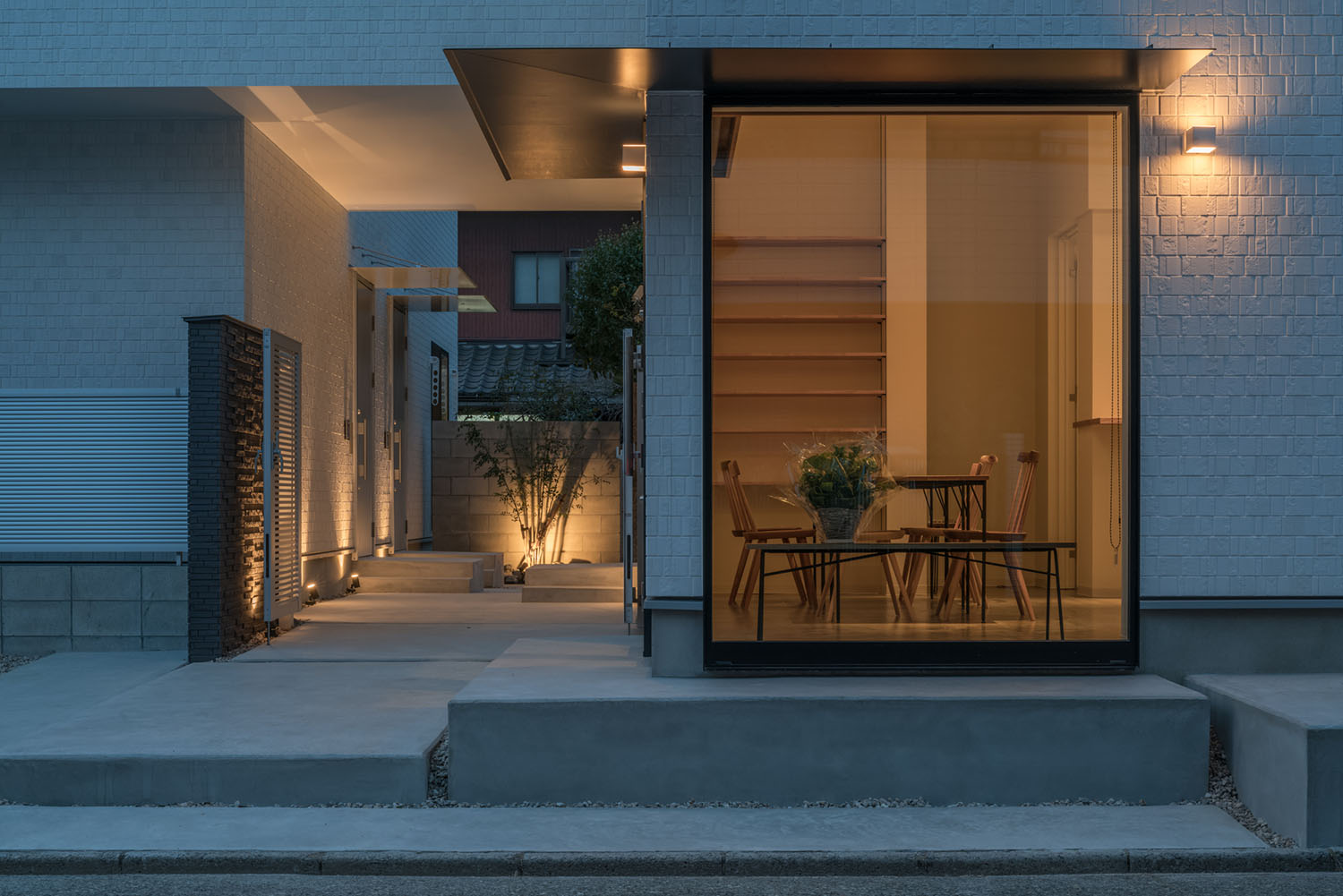 木の椅子やテーブルが置かれた一階の様子が外から見えるアパートメント・デザイン住宅 注文住宅・デザイン住宅建築実例_『CASE623 HOUSest-Life+Cafe』_外観