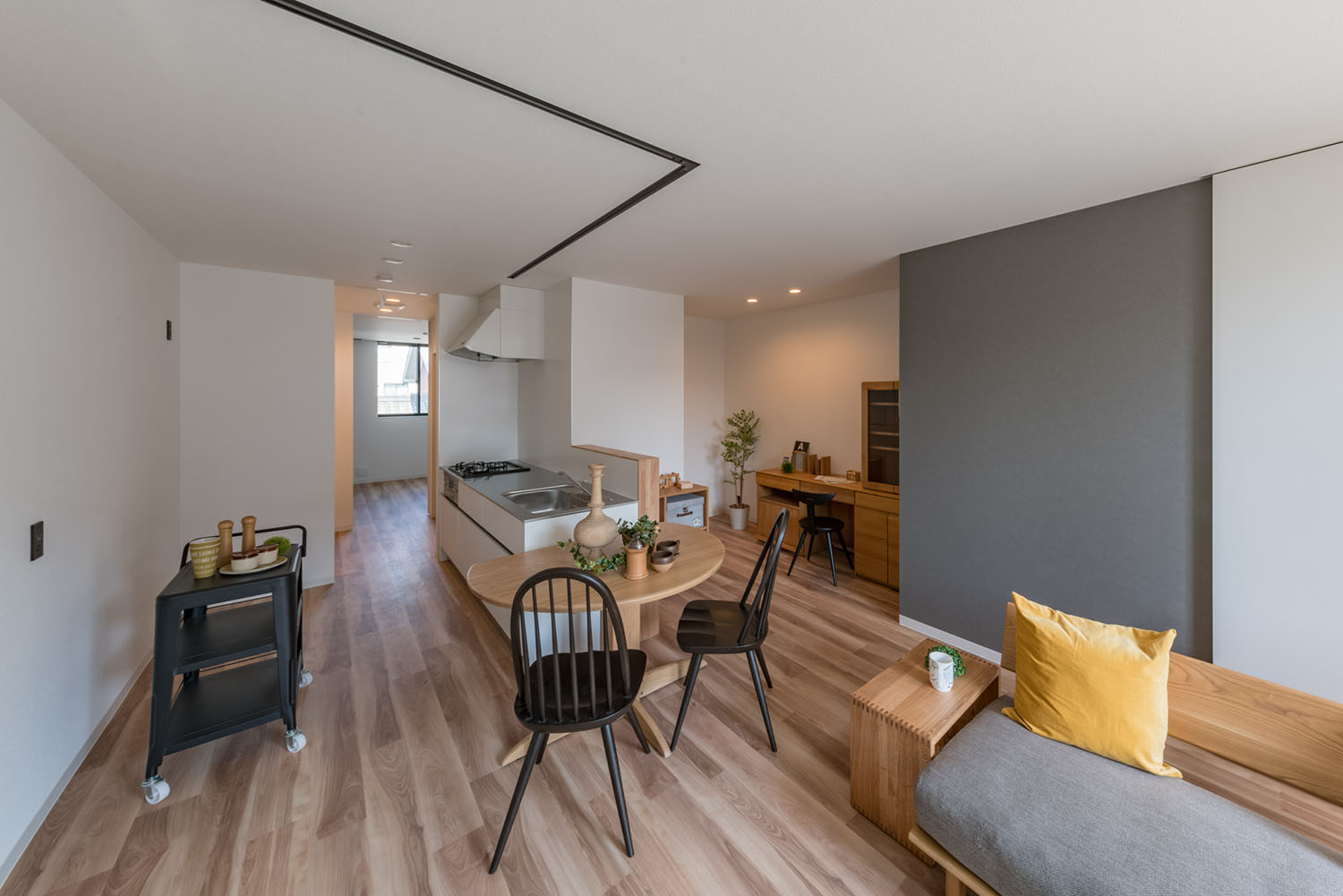 キッチンの横に木の丸テーブルと黒い椅子が置かれたLDK・デザイン住宅 注文住宅・デザイン住宅建築実例_『CASE623 HOUSest-Life+Cafe』_LDK