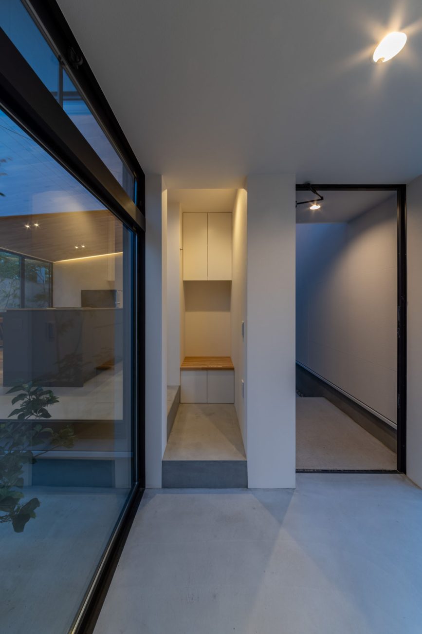 中庭の見える土間空間の先に、飾り棚がある様子・デザイン住宅 注文住宅・デザイン住宅建築実例_『CASE686  桜並木の平屋』_玄関