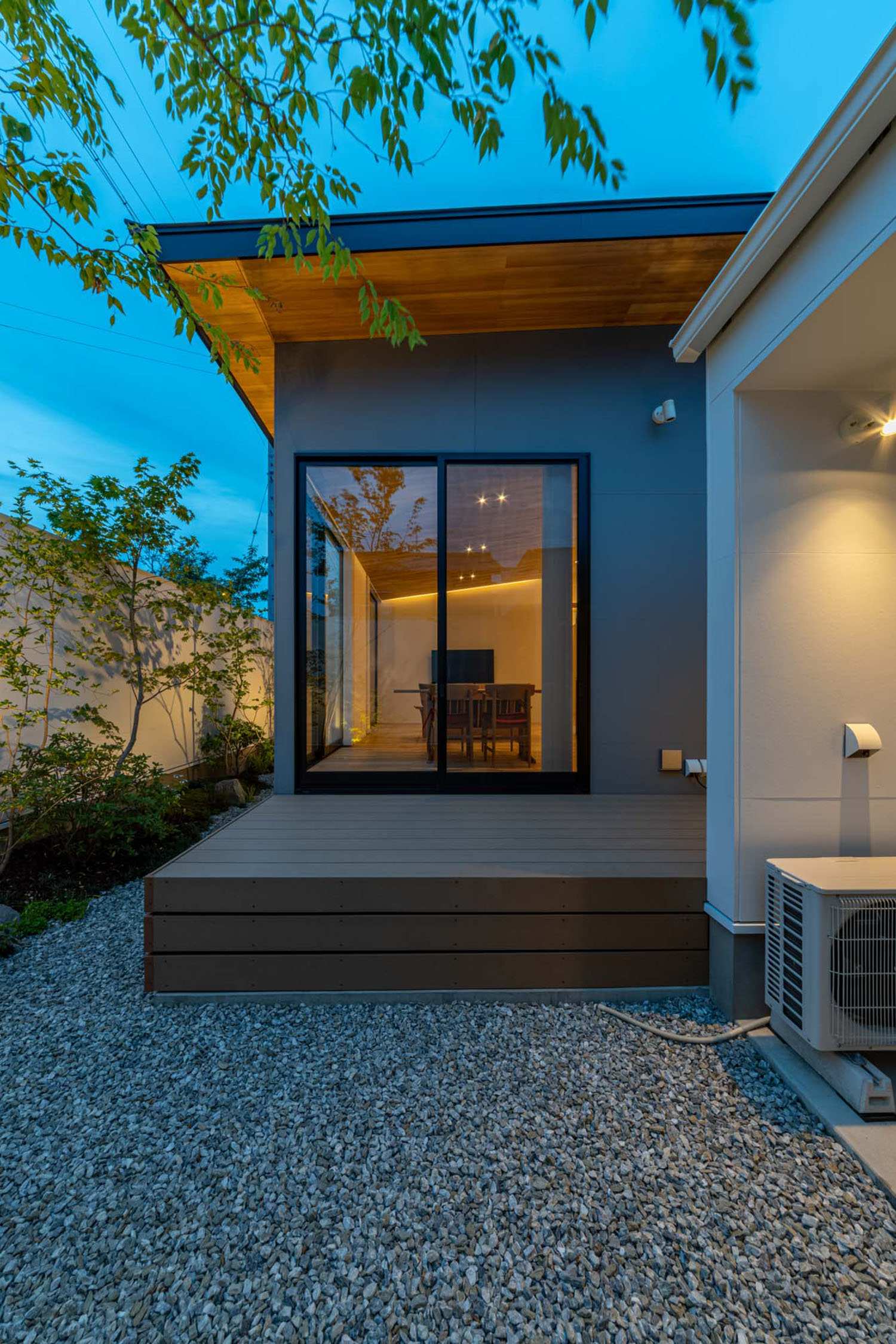 砂利が敷かれた中庭にウッドデッキのテラスがある様子・デザイン住宅 注文住宅・デザイン住宅建築実例_『CASE686 桜並木の平屋』_テラス・バルコニー