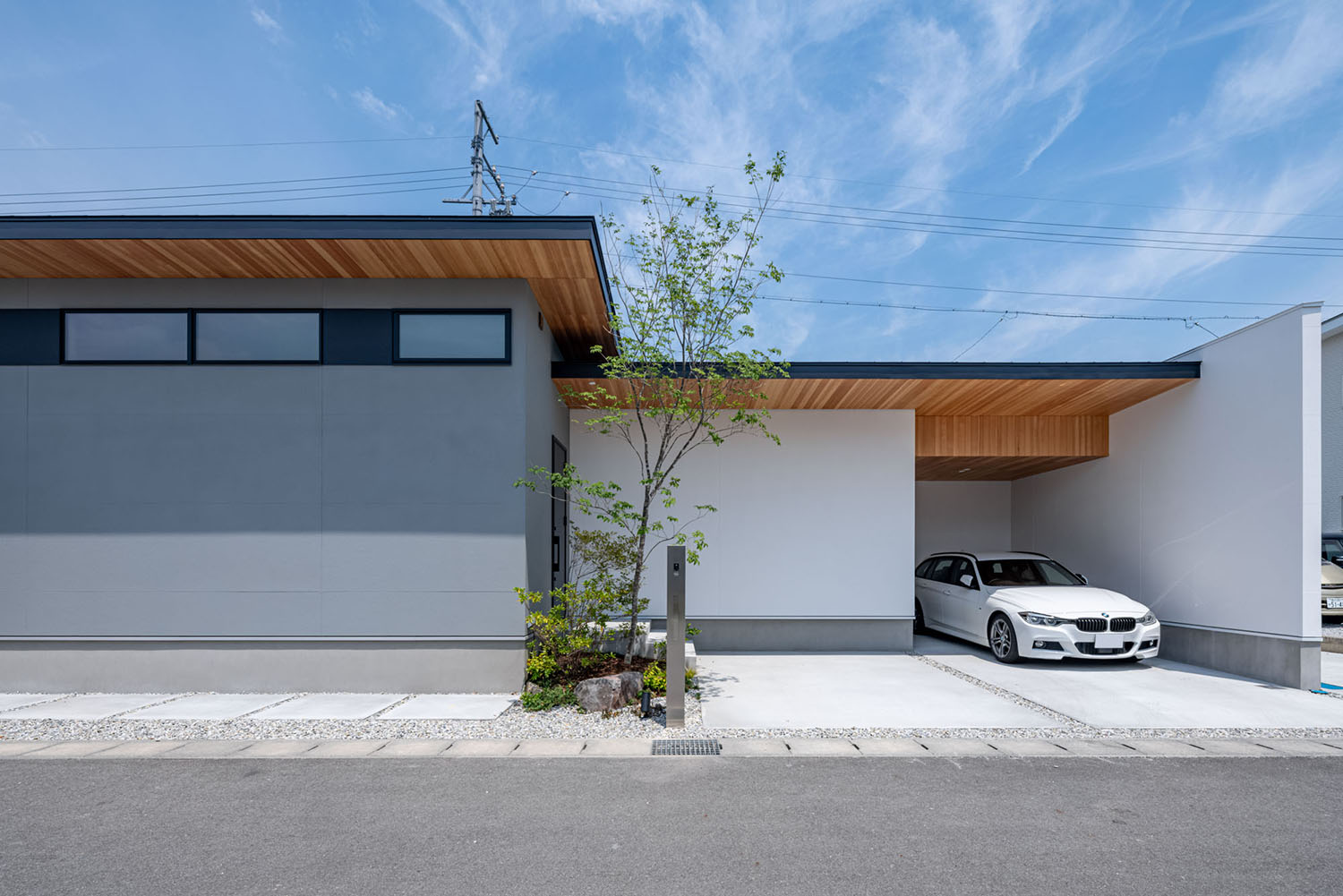 自然に馴染む白×淡いグレーのツートン塗り壁の平屋