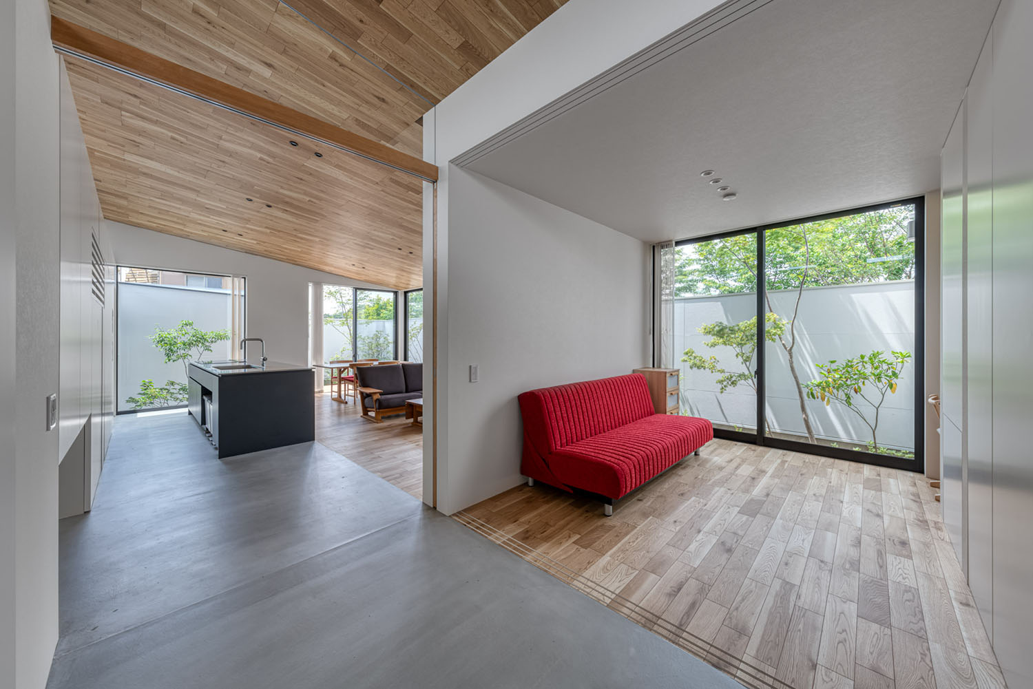 大きな窓から緑がみえる、赤いソファーのあるリビング・デザイン住宅 注文住宅・デザイン住宅建築実例_『CASE686 桜並木の平屋』_LDK