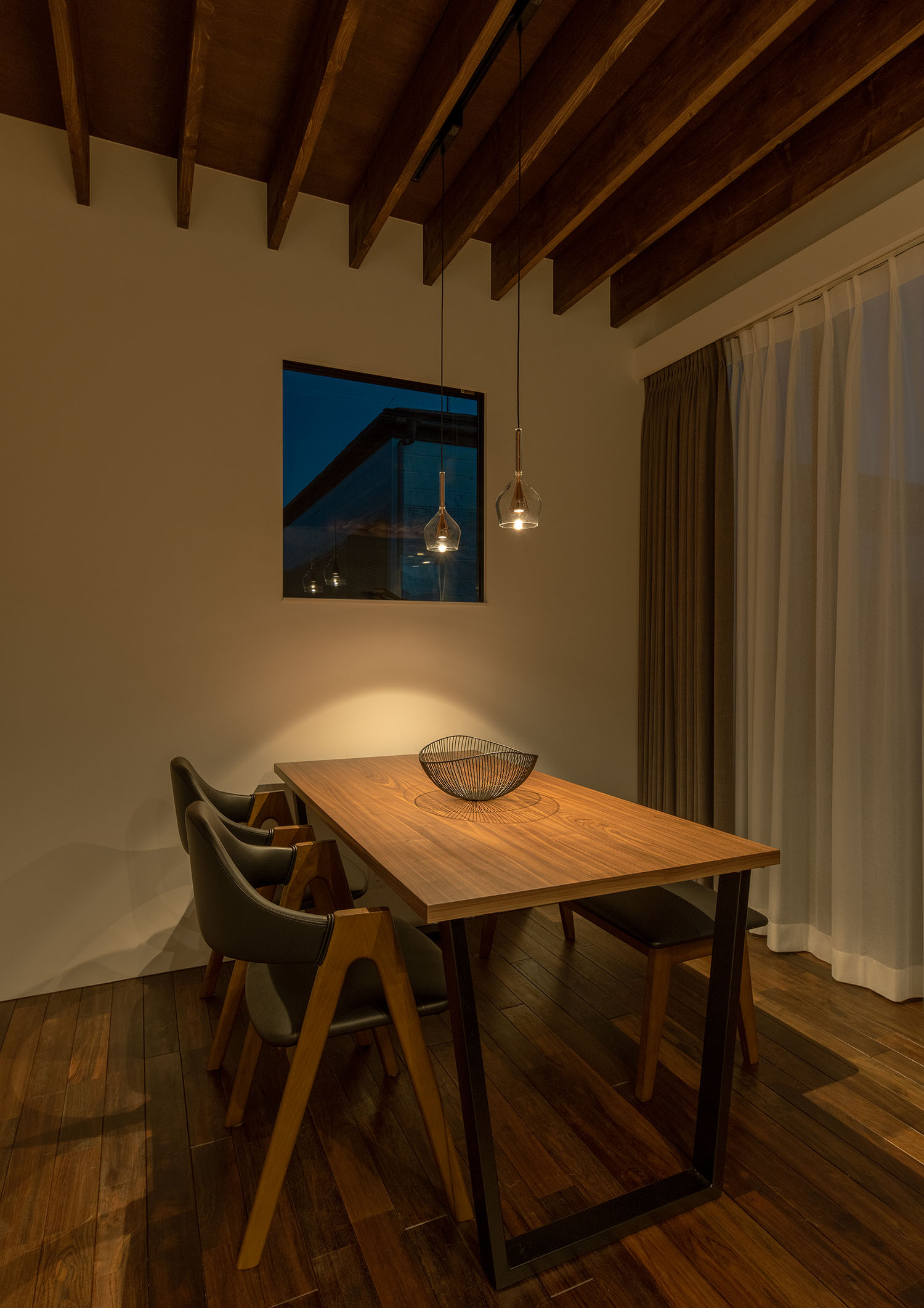 梁見せ天井に取り付けられたペンダントライトに照らされるダイニングテーブル・デザイン住宅 注文住宅・デザイン住宅建築実例_『CASE687  "□×□×和 （ハコニワ）"』_LDK