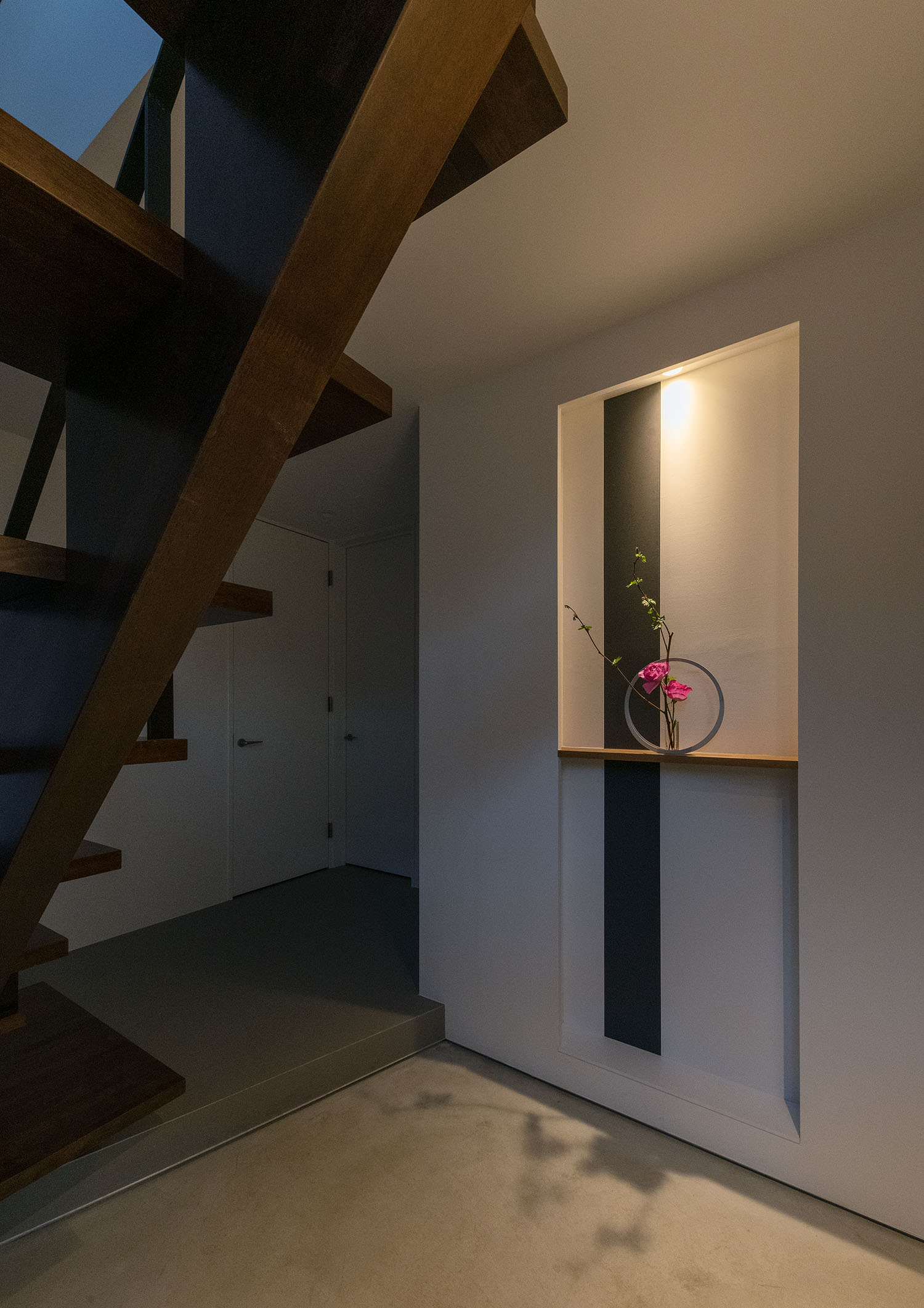 間接照明付きの飾り棚に、生け花が飾られているモルタルの玄関・デザイン住宅 注文住宅・デザイン住宅建築実例_『CASE687  "□×□×和 （ハコニワ）"』_玄関