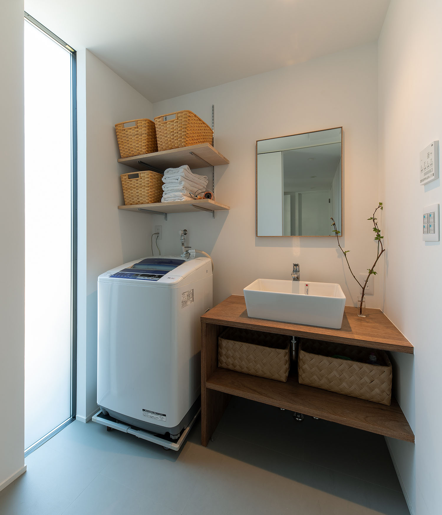 洗面ボウルの隣に洗濯機がある白を基調とした洗面所・デザイン住宅 注文住宅・デザイン住宅建築実例_『CASE687  "□×□×和 （ハコニワ）"』_浴室・洗面所