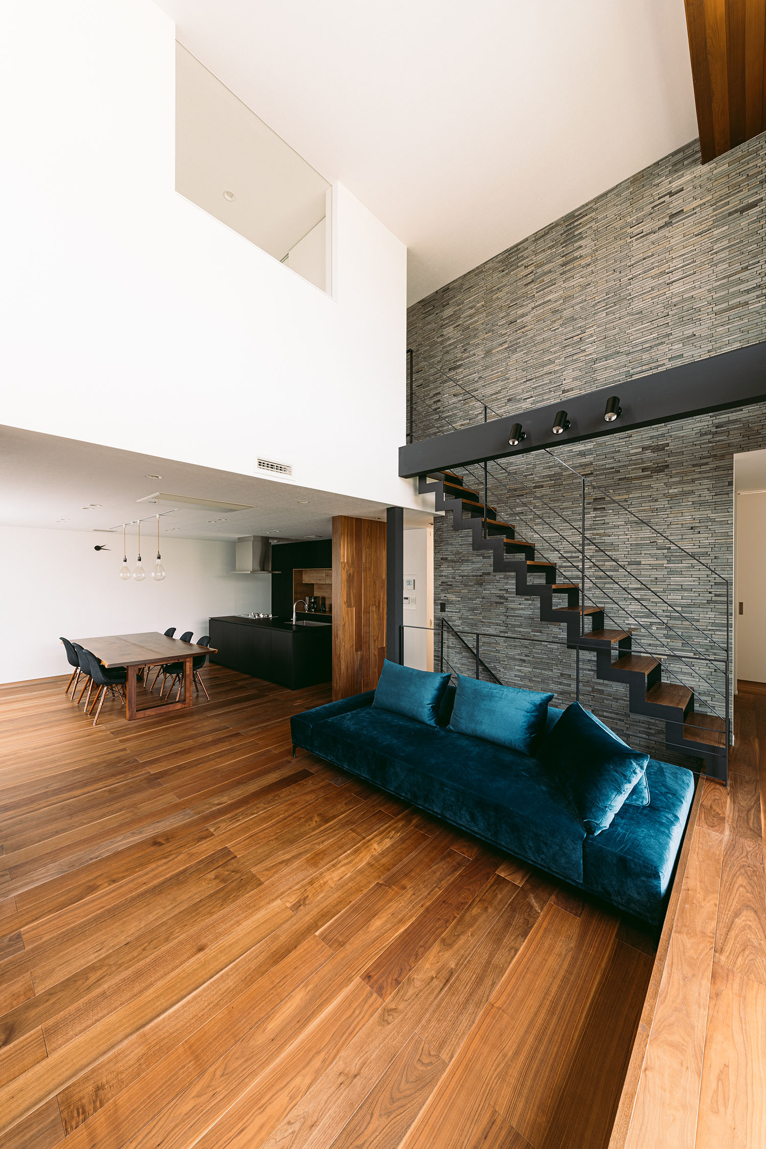 青いソファーが置かれている、吹き抜けのLDK・デザイン住宅 注文住宅・デザイン住宅建築実例_『CASE688 Transition』_LDK