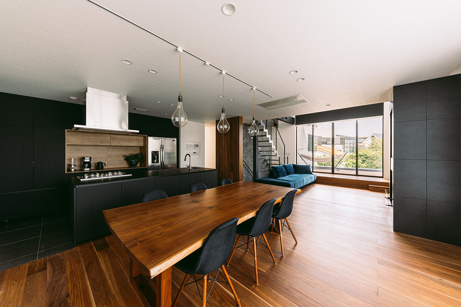 フローリングの空間に黒のキッチンがあるLDK・デザイン住宅 注文住宅・デザイン住宅建築実例_『CASE688 Transition』_LDK