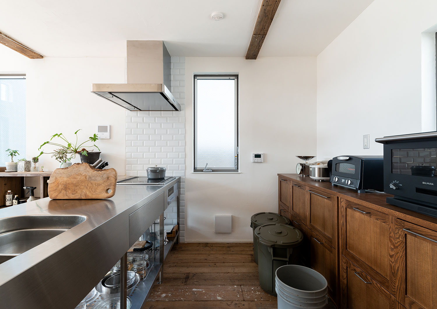 ステンレスのペニンシュラキッチンの背面に木製の棚がある・デザイン住宅 注文住宅・デザイン住宅建築実例_『CASE690 質感にこだわった完成を楽しむ家』_キッチン