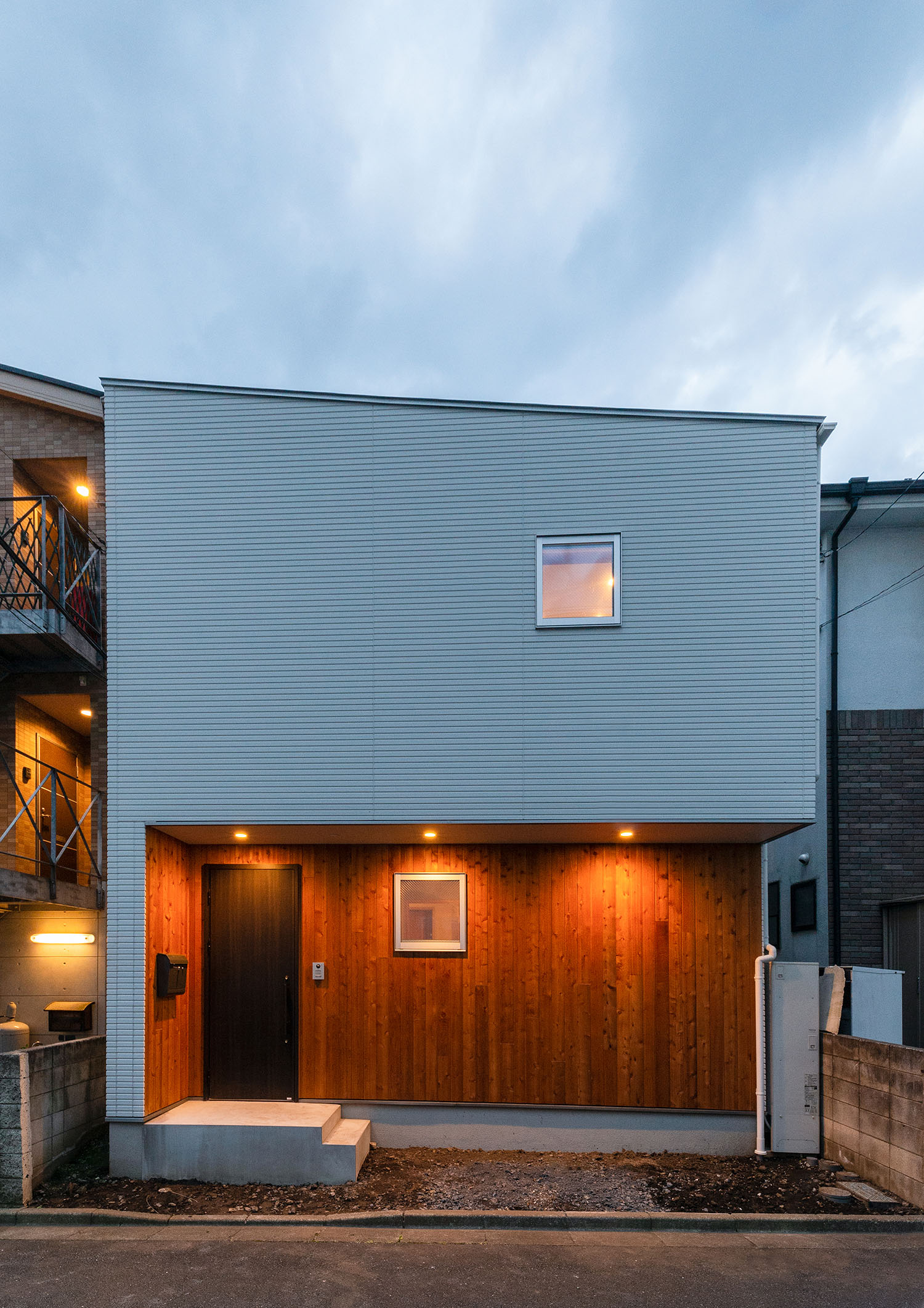 軒下にダウンライトが取り付けられた白い外壁の住宅・デザイン住宅 注文住宅・デザイン住宅建築実例_『CASE690 質感にこだわった完成を楽しむ家』_外観