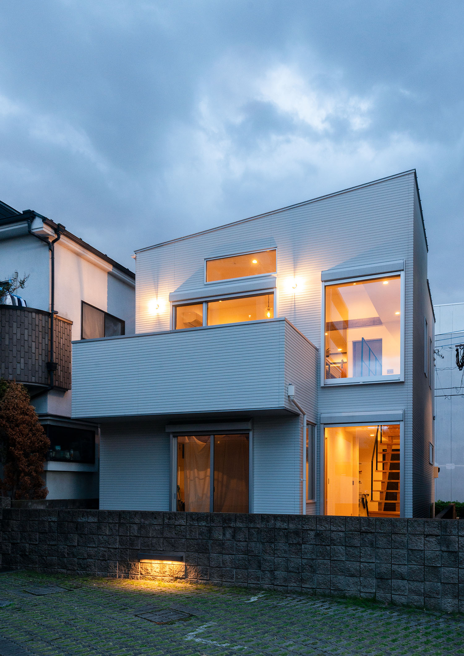 外壁に間接照明が設けられた白い外壁の住宅・デザイン住宅 注文住宅・デザイン住宅建築実例_『CASE690 質感にこだわった完成を楽しむ家』_外観