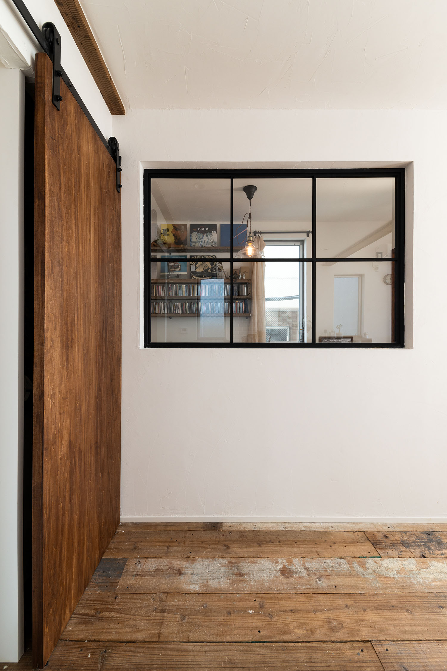 ガラスの室内窓が木材を中心とした空間にある・デザイン住宅 注文住宅・デザイン住宅建築実例_『CASE690 質感にこだわった完成を楽しむ家』_LDK